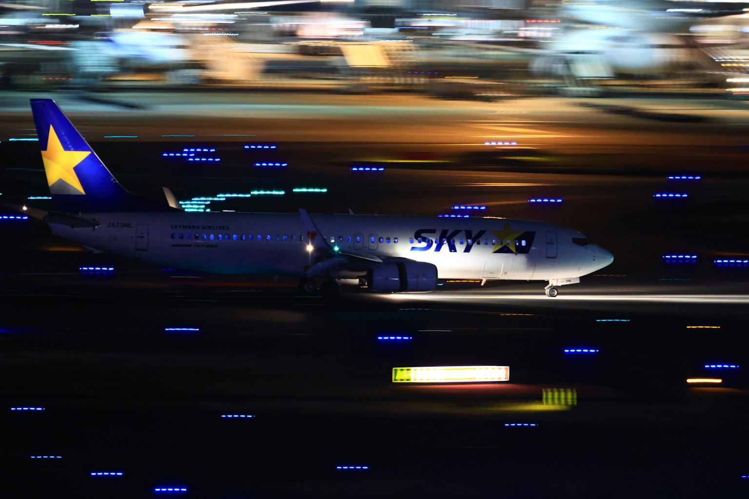 Ein blau mit Stern markiertes Flugzeug, das auf einer Flughafenpiste startet