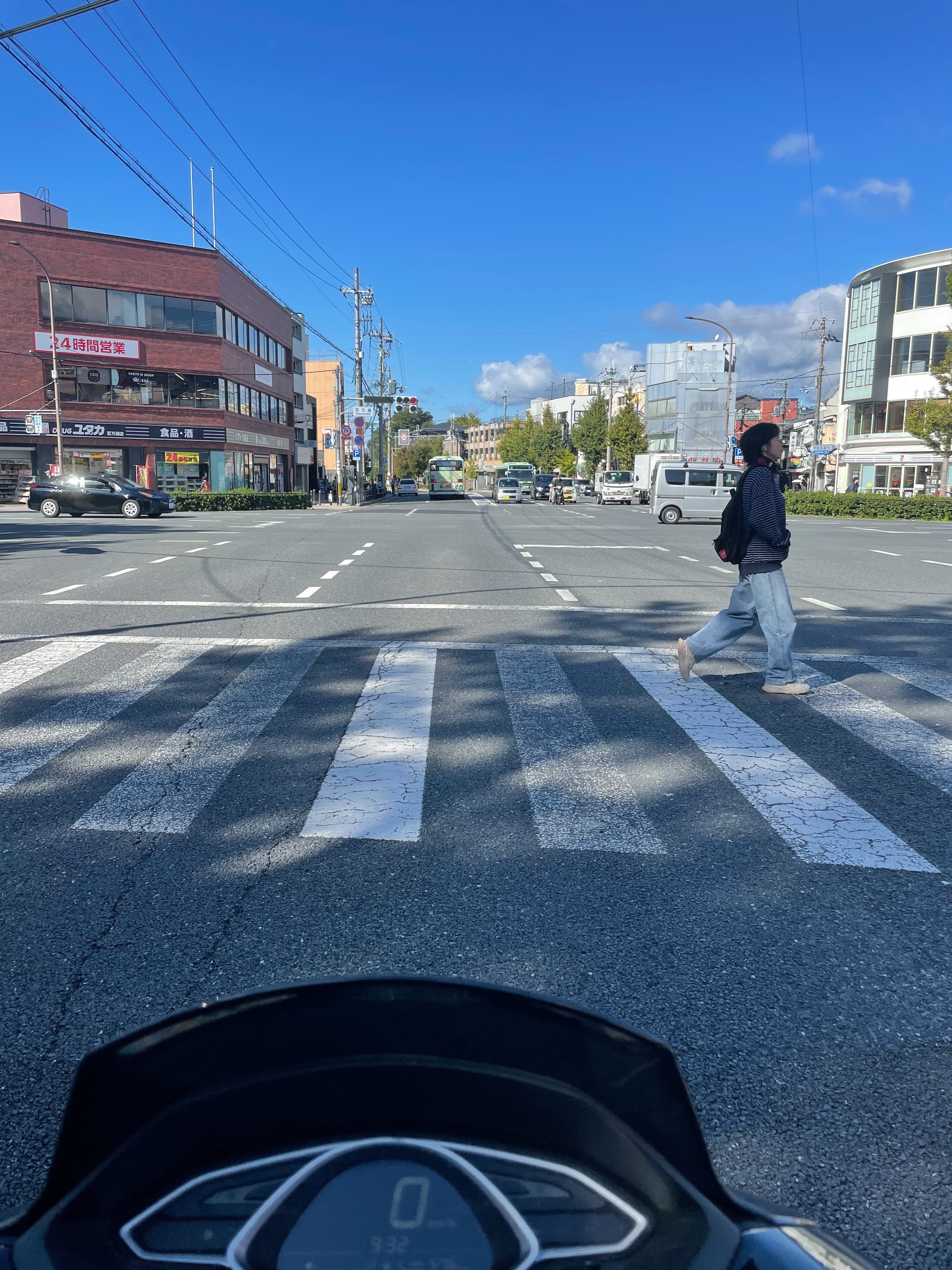 京都・百万遍交差点の横断歩道をバイクで走る風景