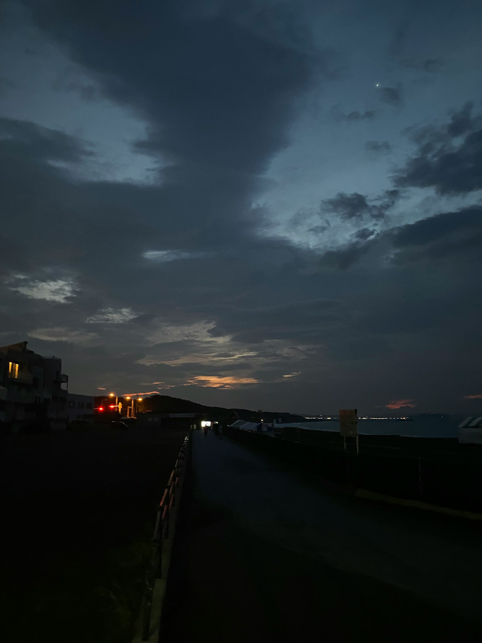 Jalan pesisir saat senja dengan langit berawan