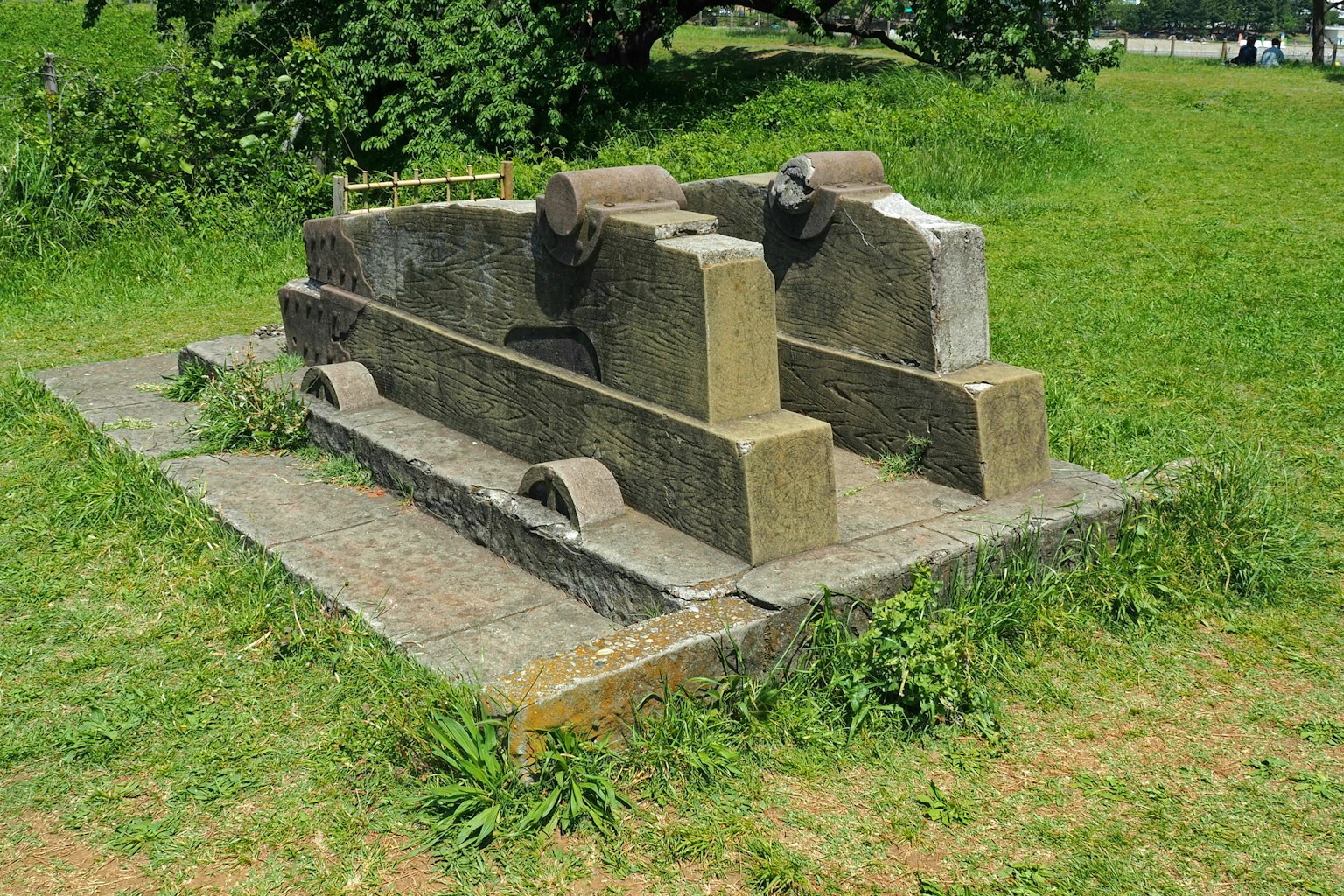 Dos estructuras de piedra antiguas rodeadas de hierba