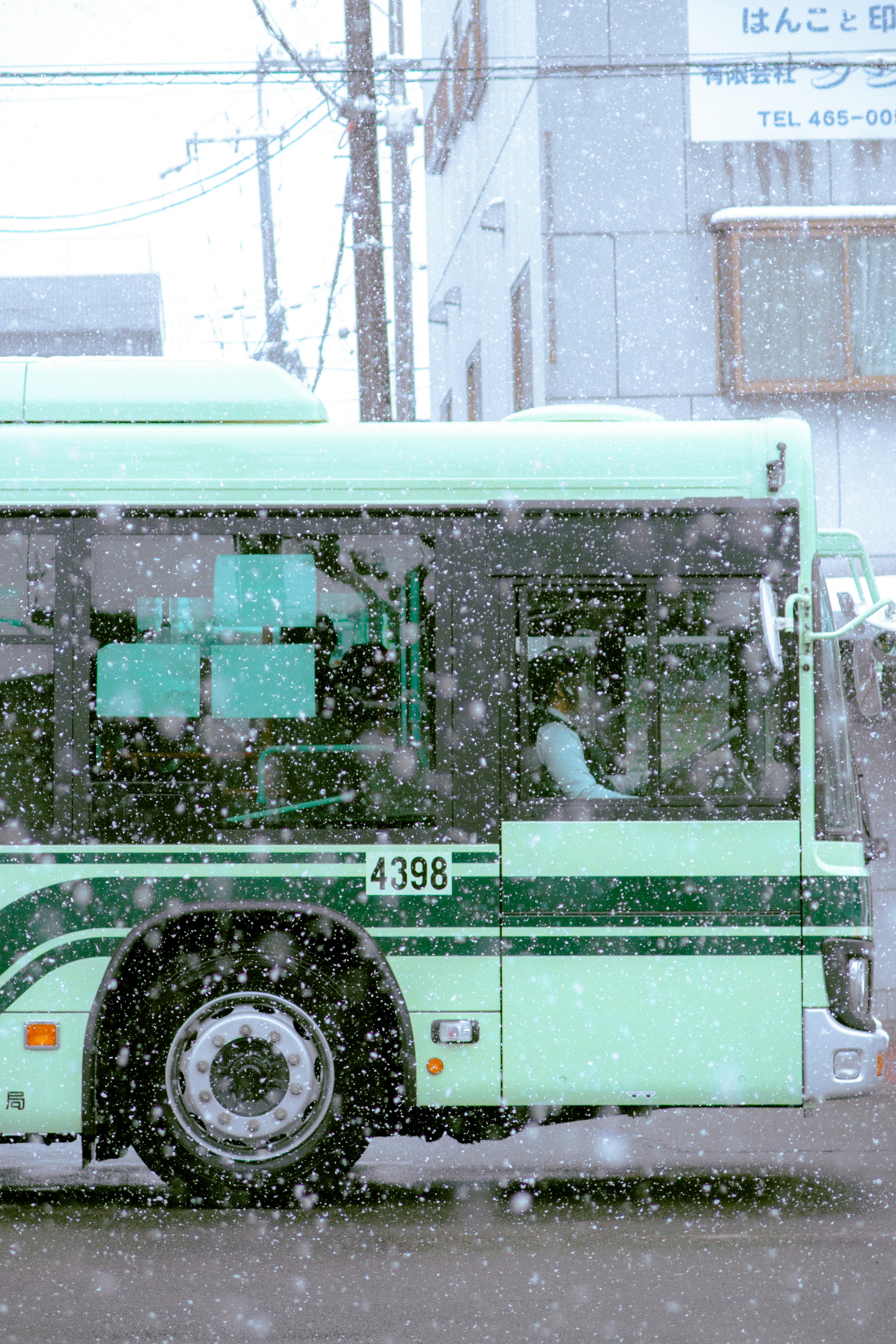 大雪の中を走るバスと街並み