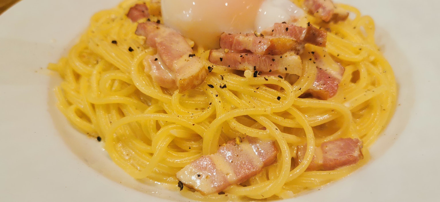 Spaghetti Carbonara mit pochiertem Ei und Speck