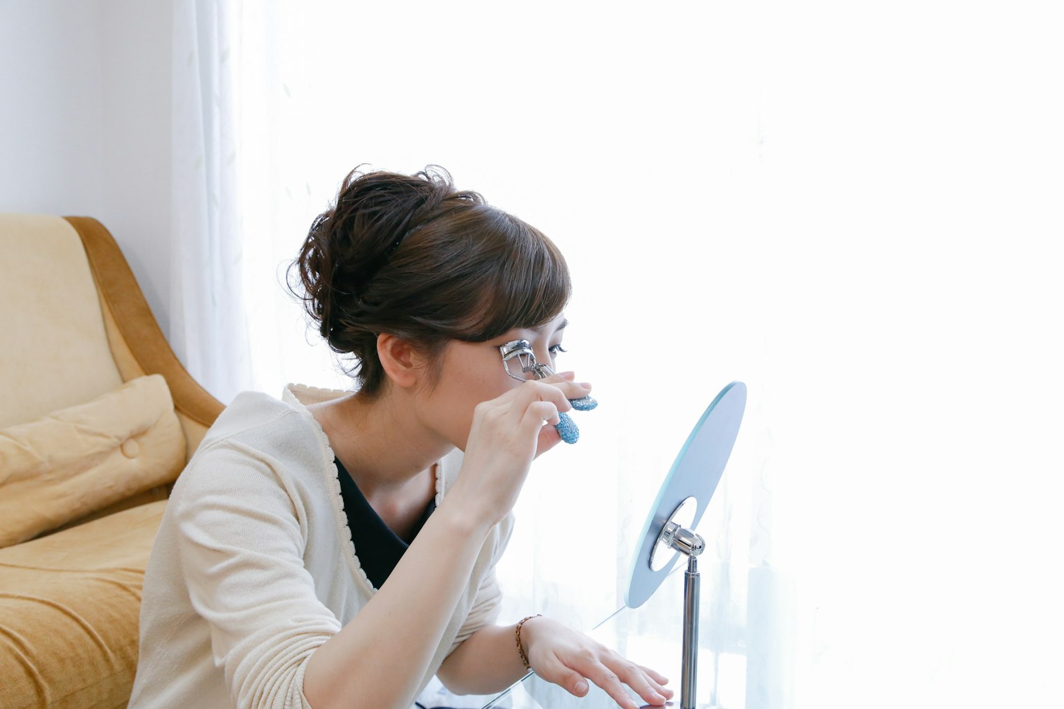 一位女性在明亮的房间里用自然光查看镜子中的东西