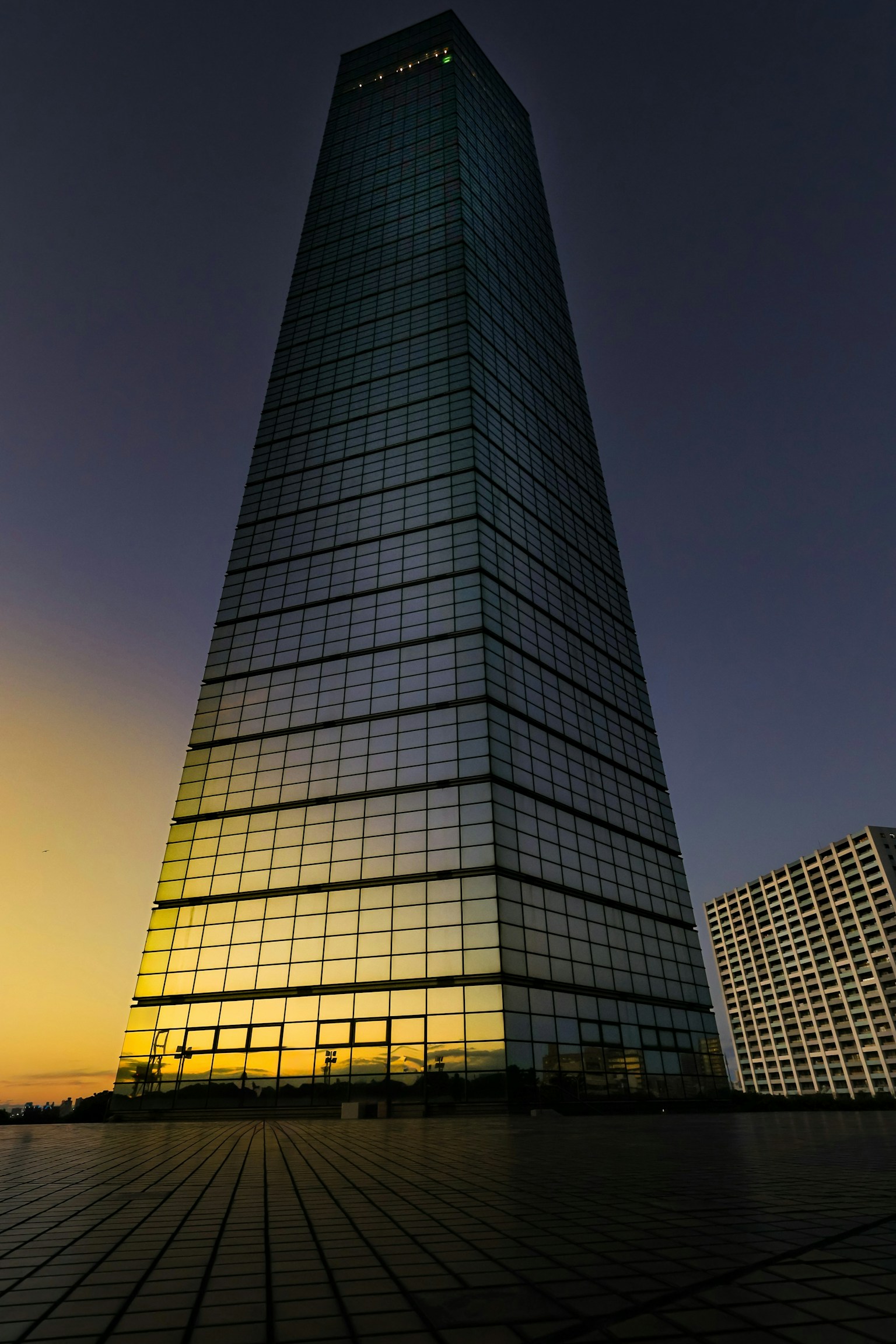 Tall skyscraper reflecting sunset colors with a modern design