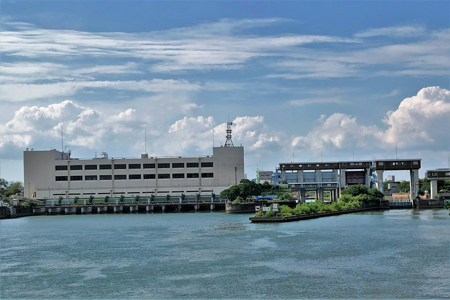 河邊景觀，建築和橋樑在藍天和白雲下