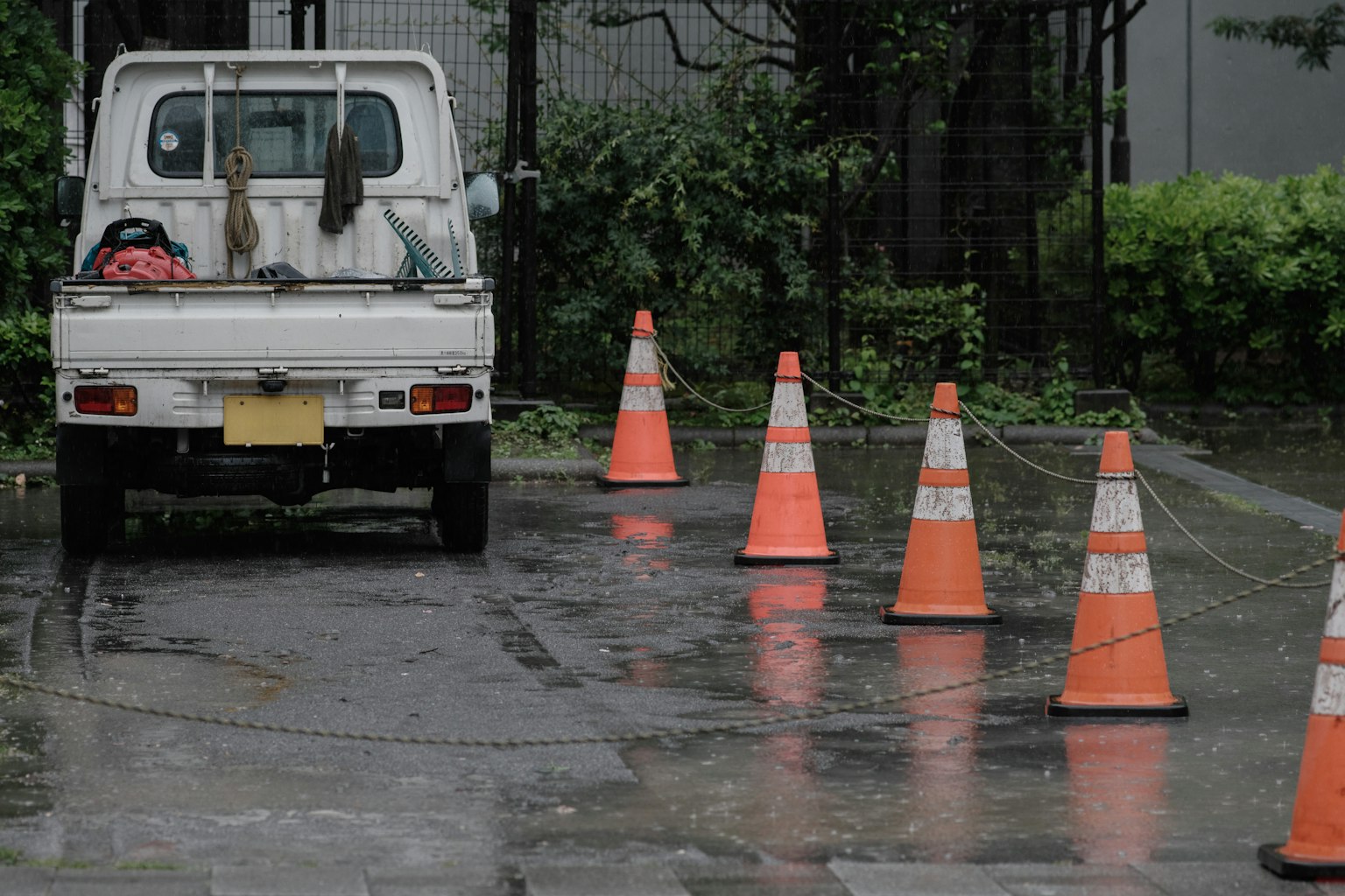 Weißer Truck, der im Regen mit orangefarbenen Verkehrsleitkegeln geparkt ist