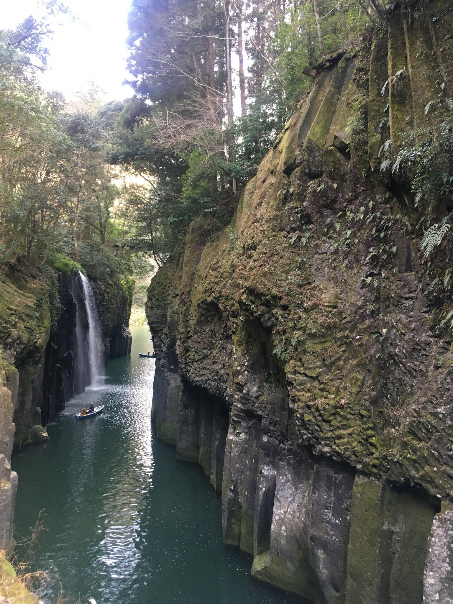 Cañón pintoresco rodeado de acantilados exuberantes y una hermosa cascada