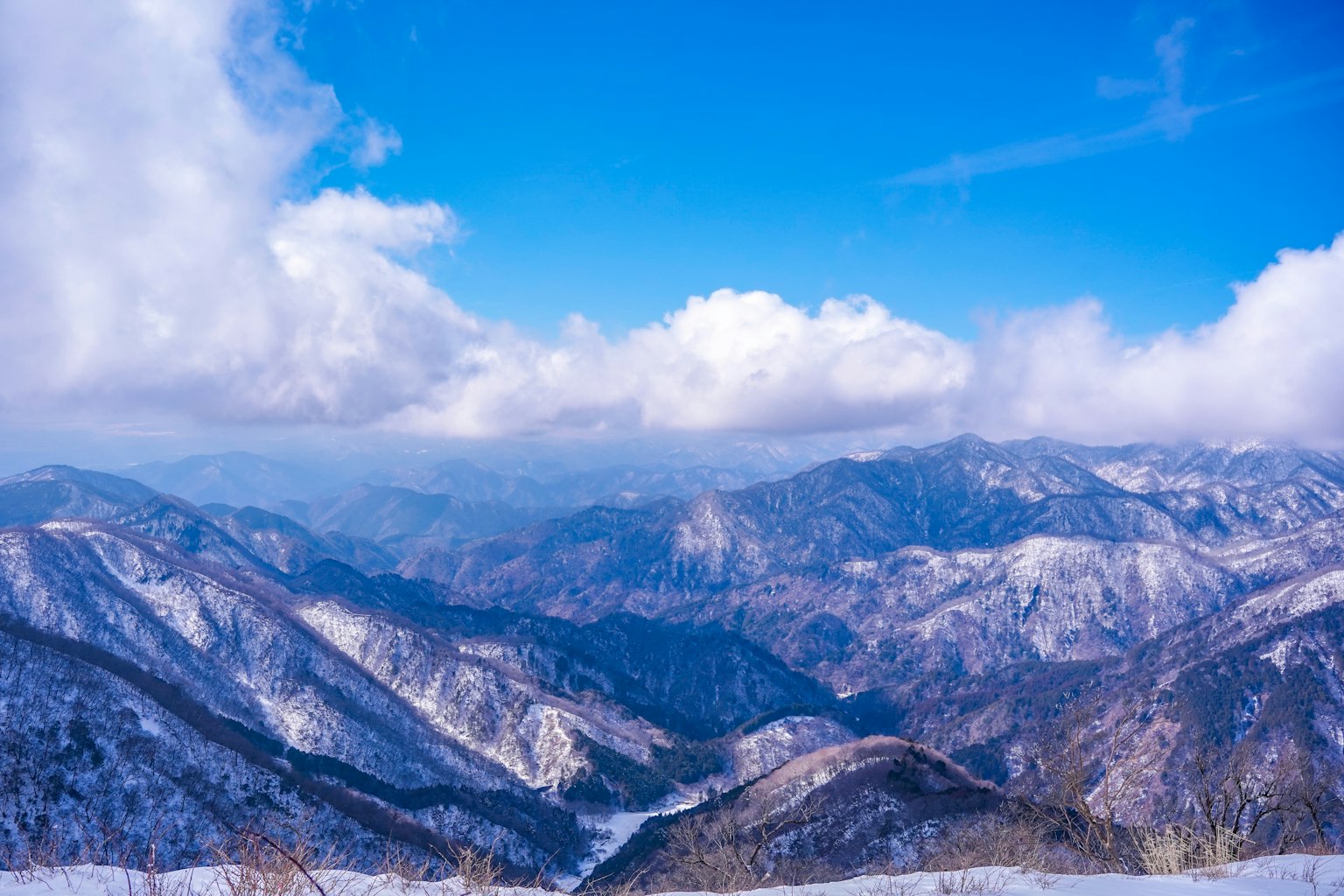 맑은 파란 하늘 아래 눈 덮인 산들