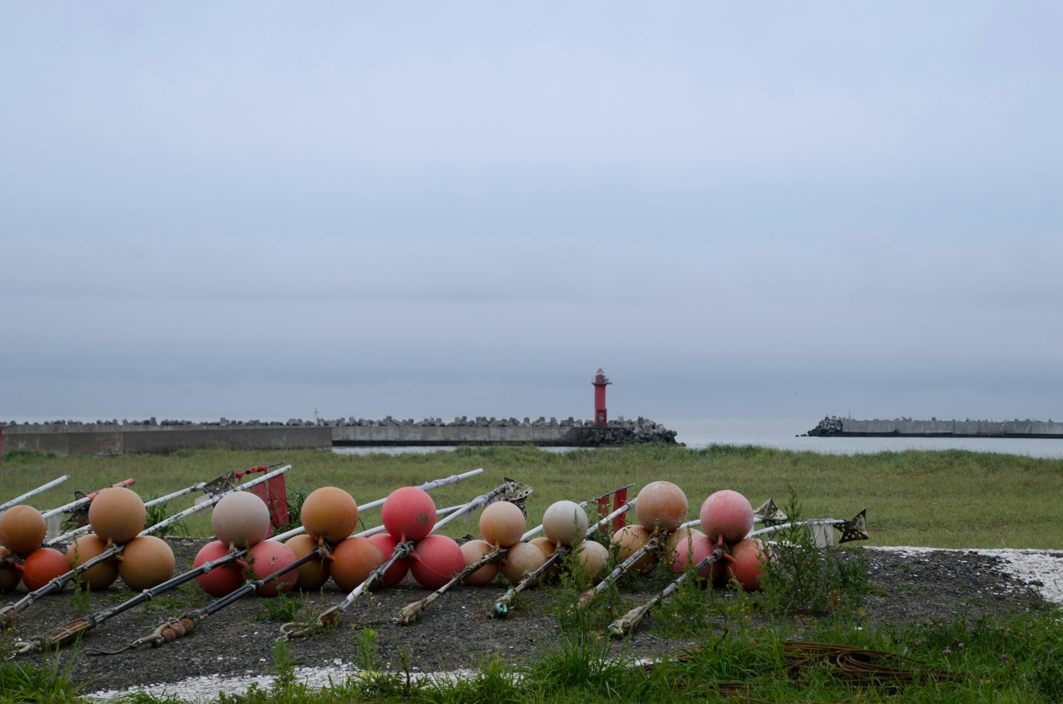 海岸上排列的浮標和背景中的紅色燈塔