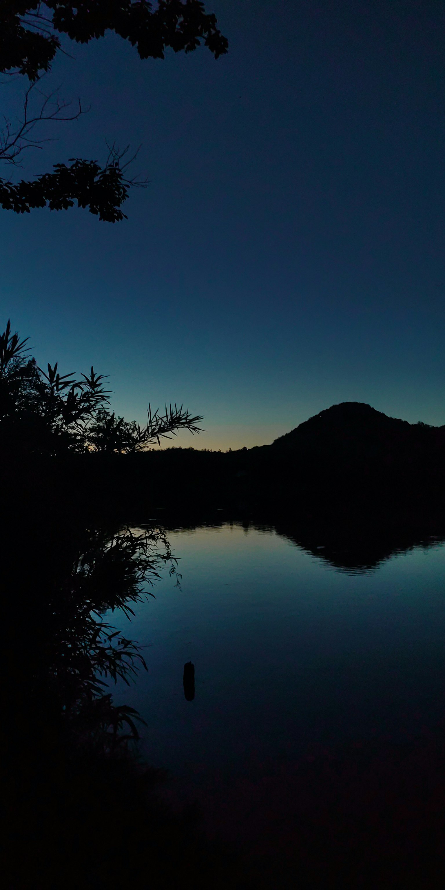 Ruhige Sonnenuntergangsansicht über einen See mit Bergsilhouette