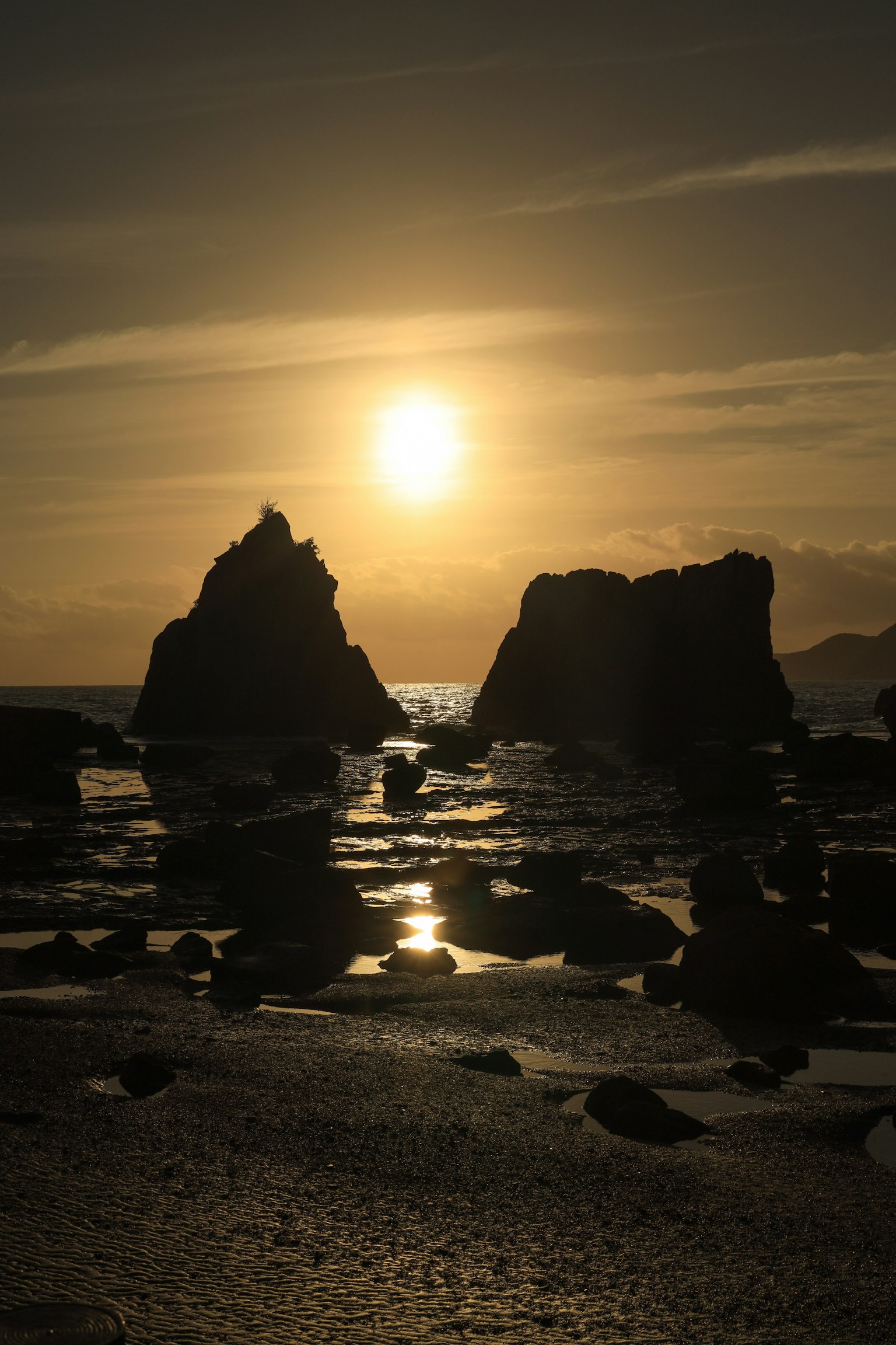 Paesaggio costiero con il tramonto che si riflette sulle rocce