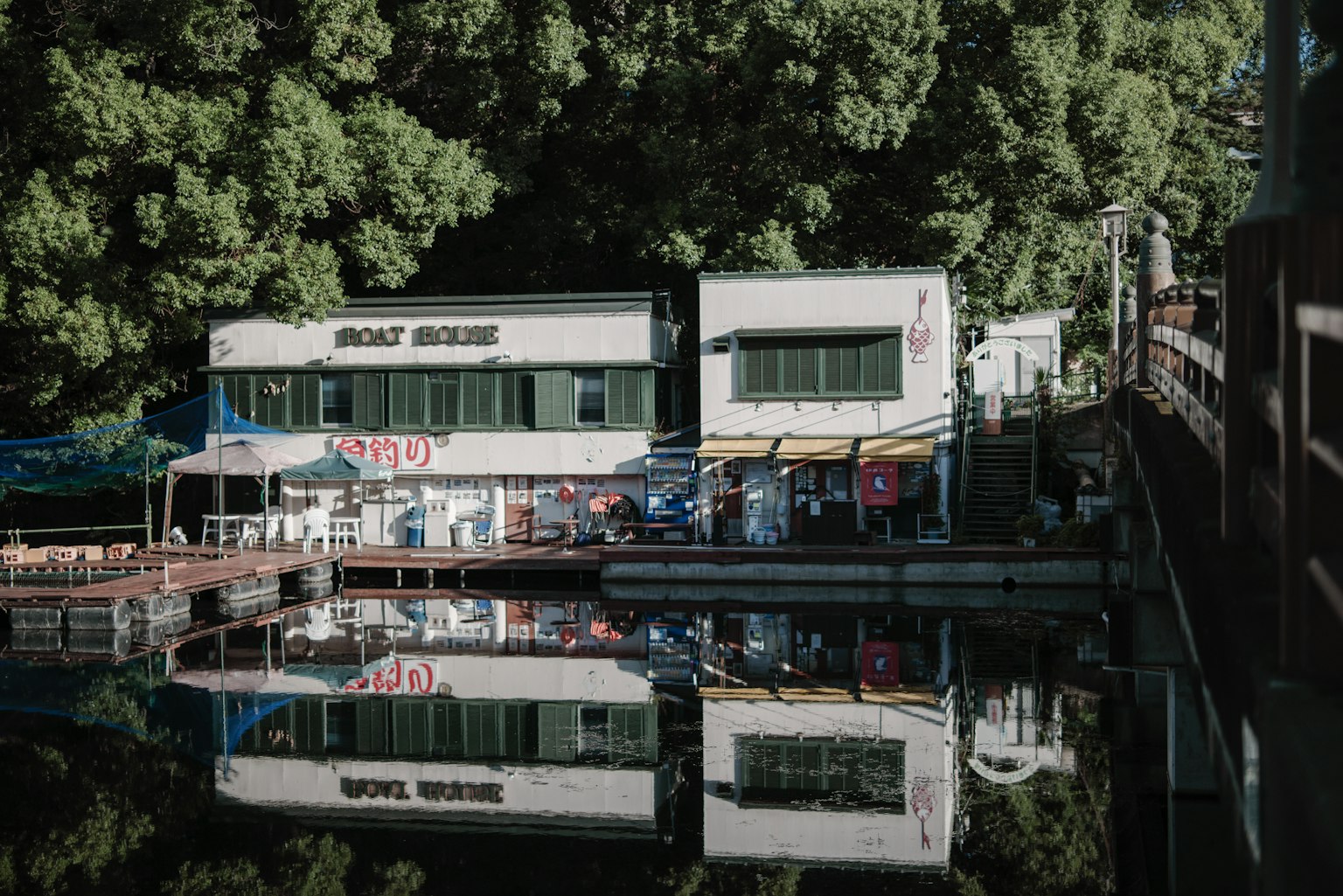 Restaurante junto al agua rodeado de vegetación con reflejo en el agua