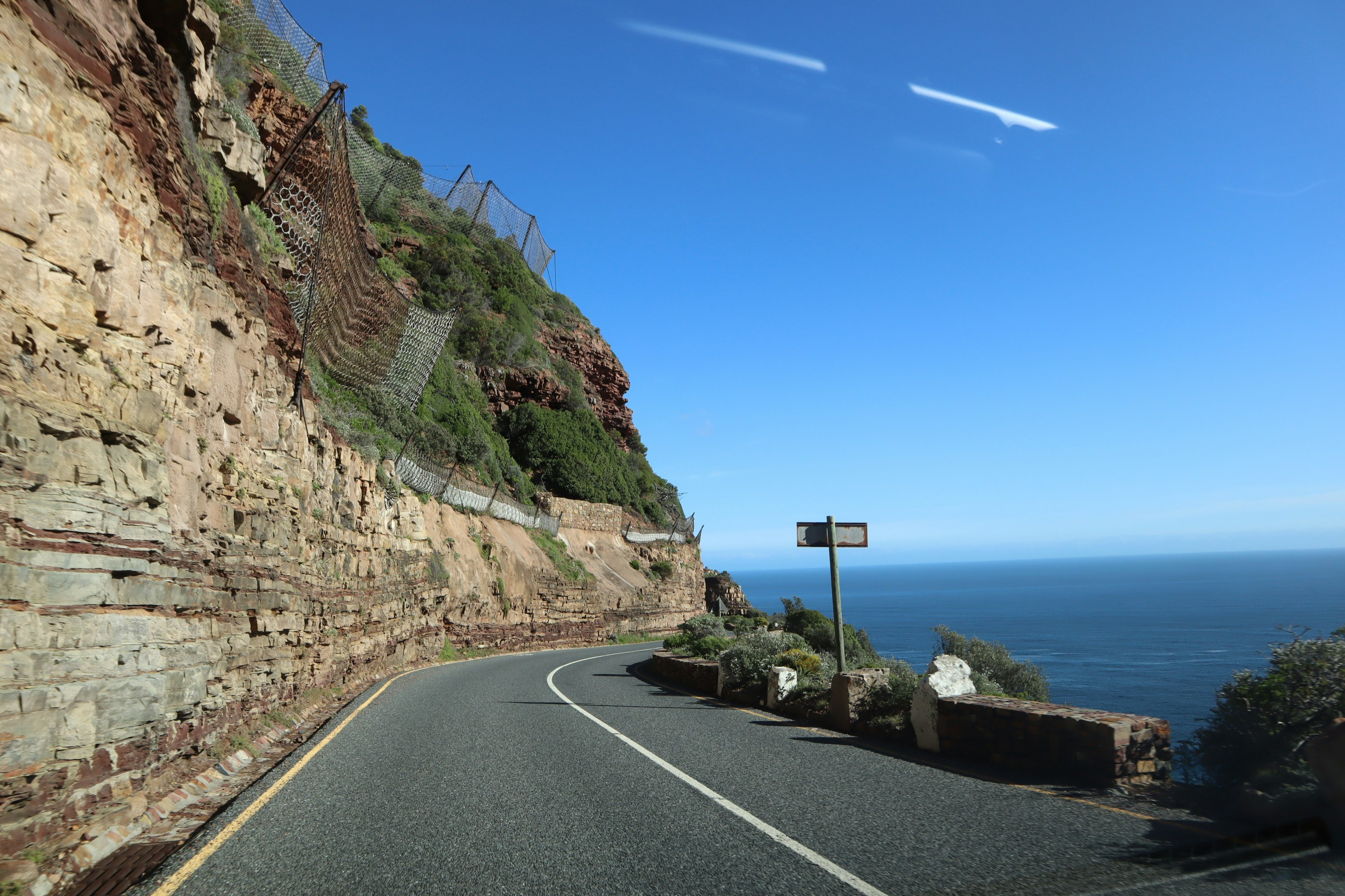strada costiera che curva lungo una scogliera sul mare