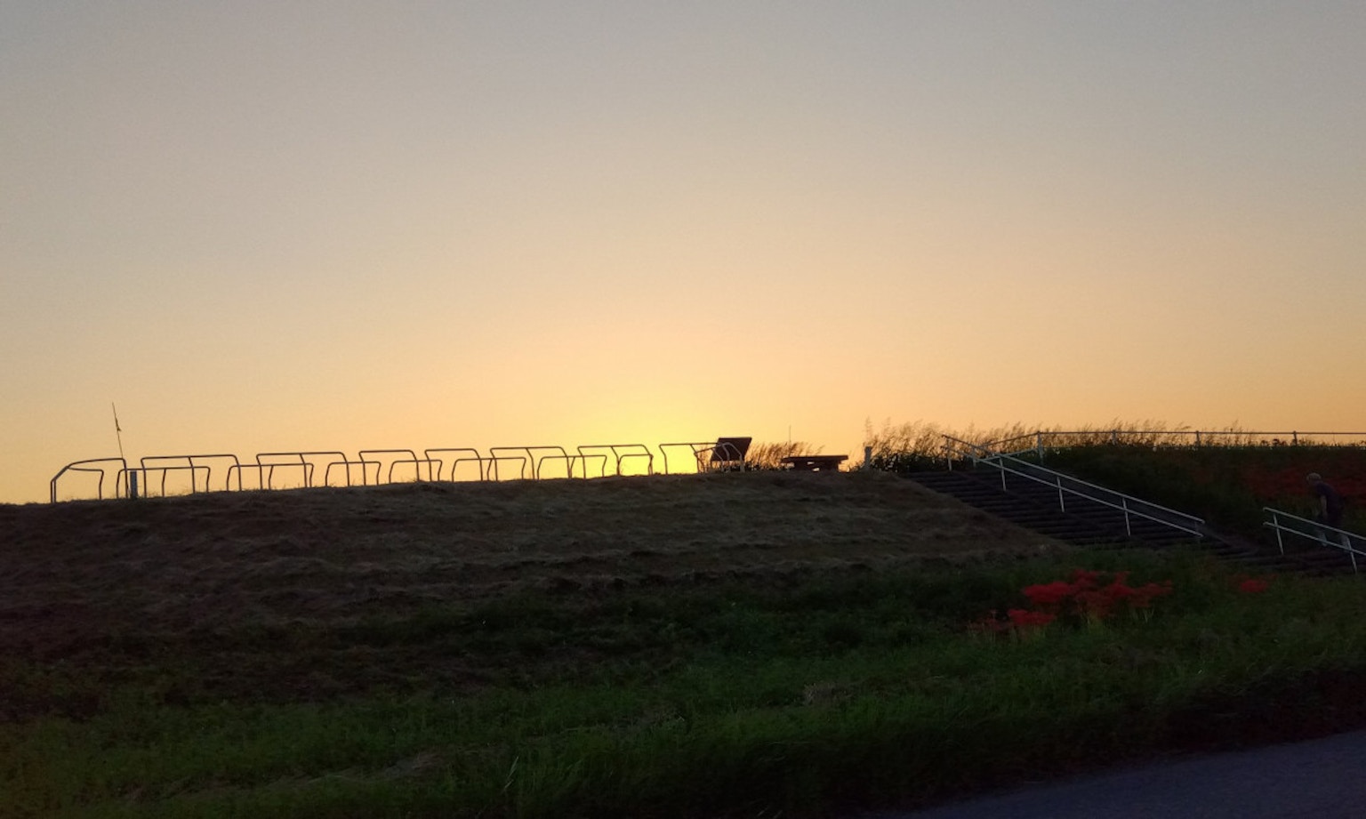 Silhouette di una collina con una recinzione al tramonto