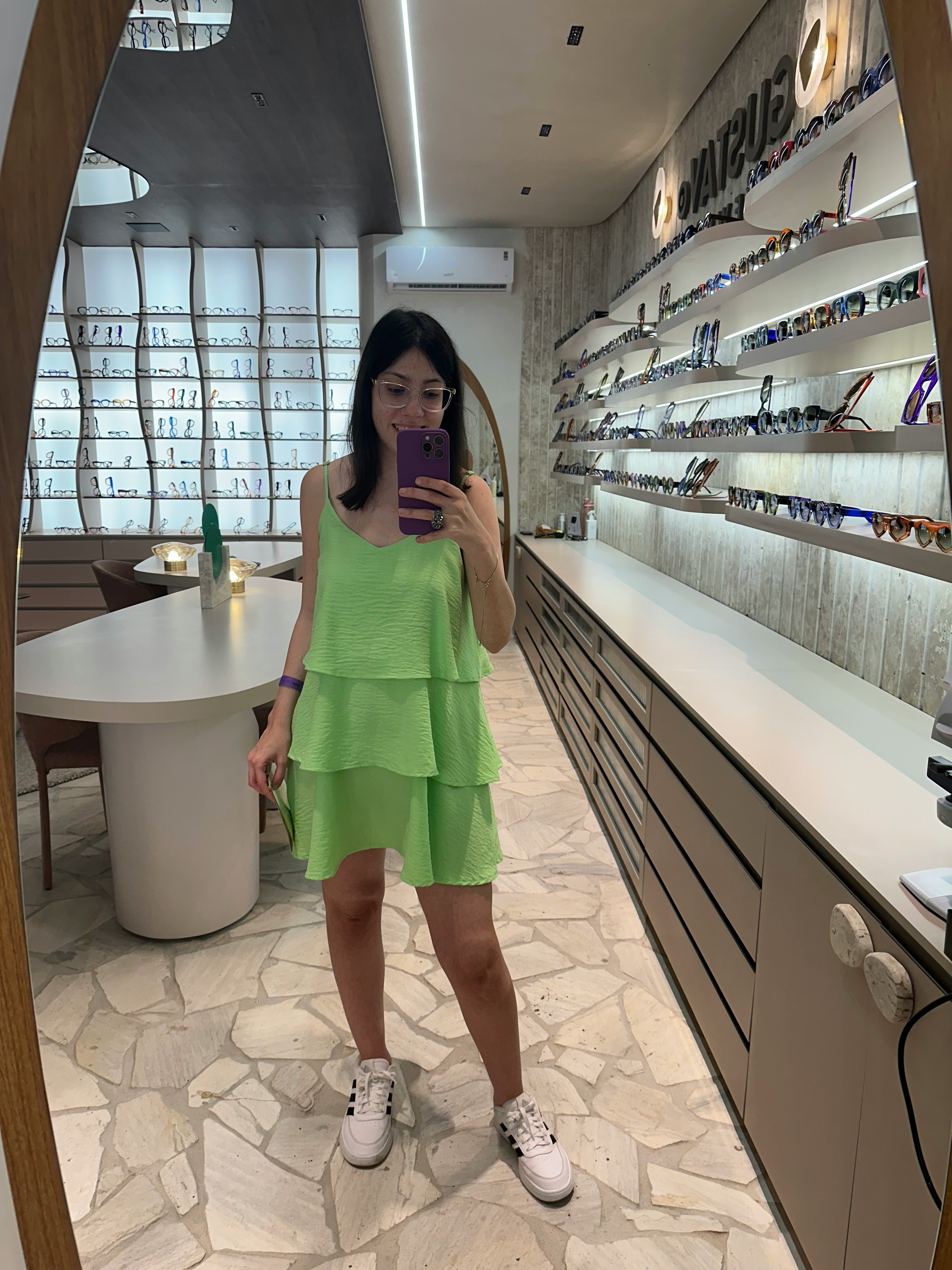 鏡越しに撮影した緑のワンピースの女性と店内の棚