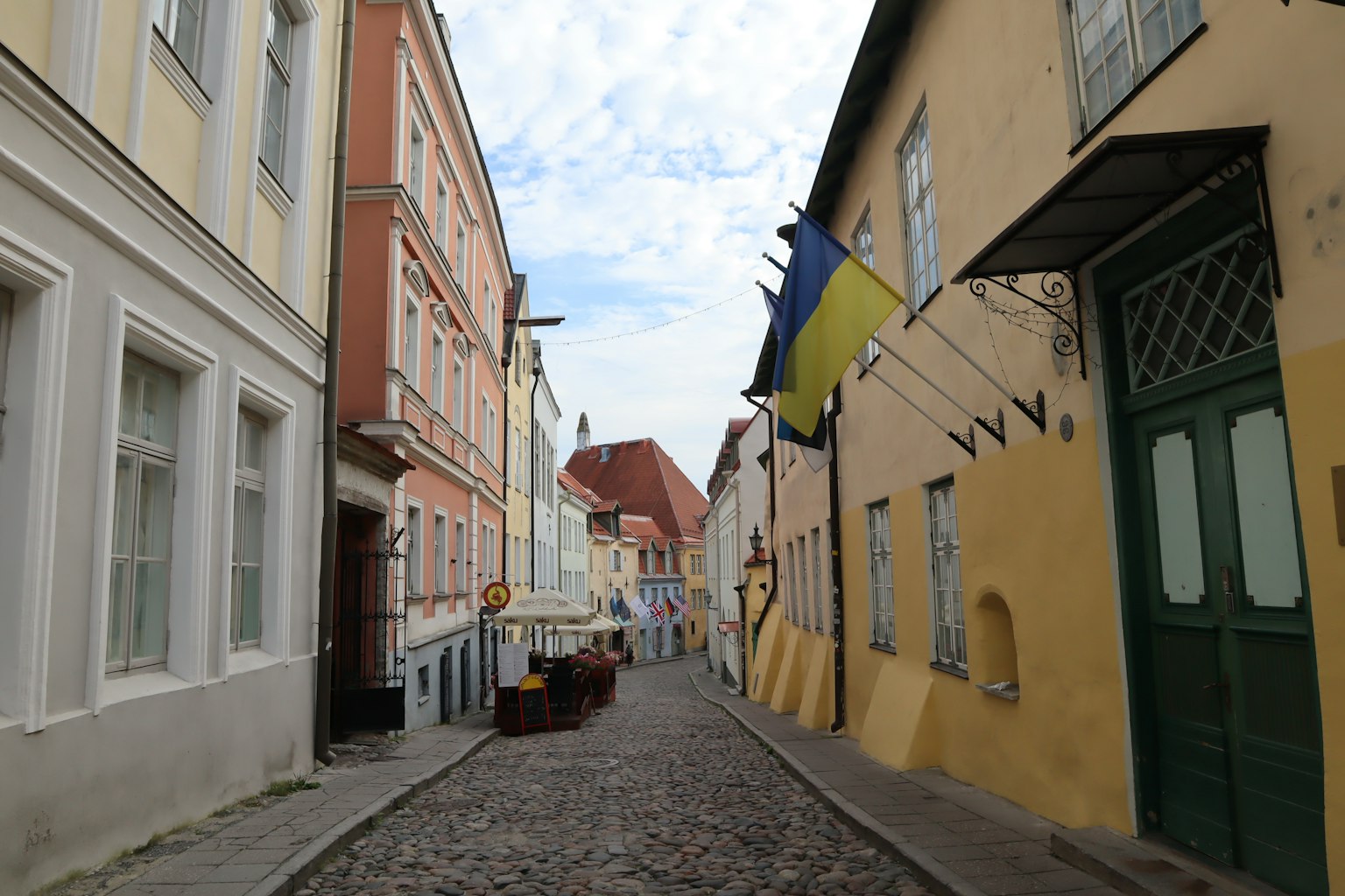 Colorful buildings lining a cobblestone street with a Ukrainian flag