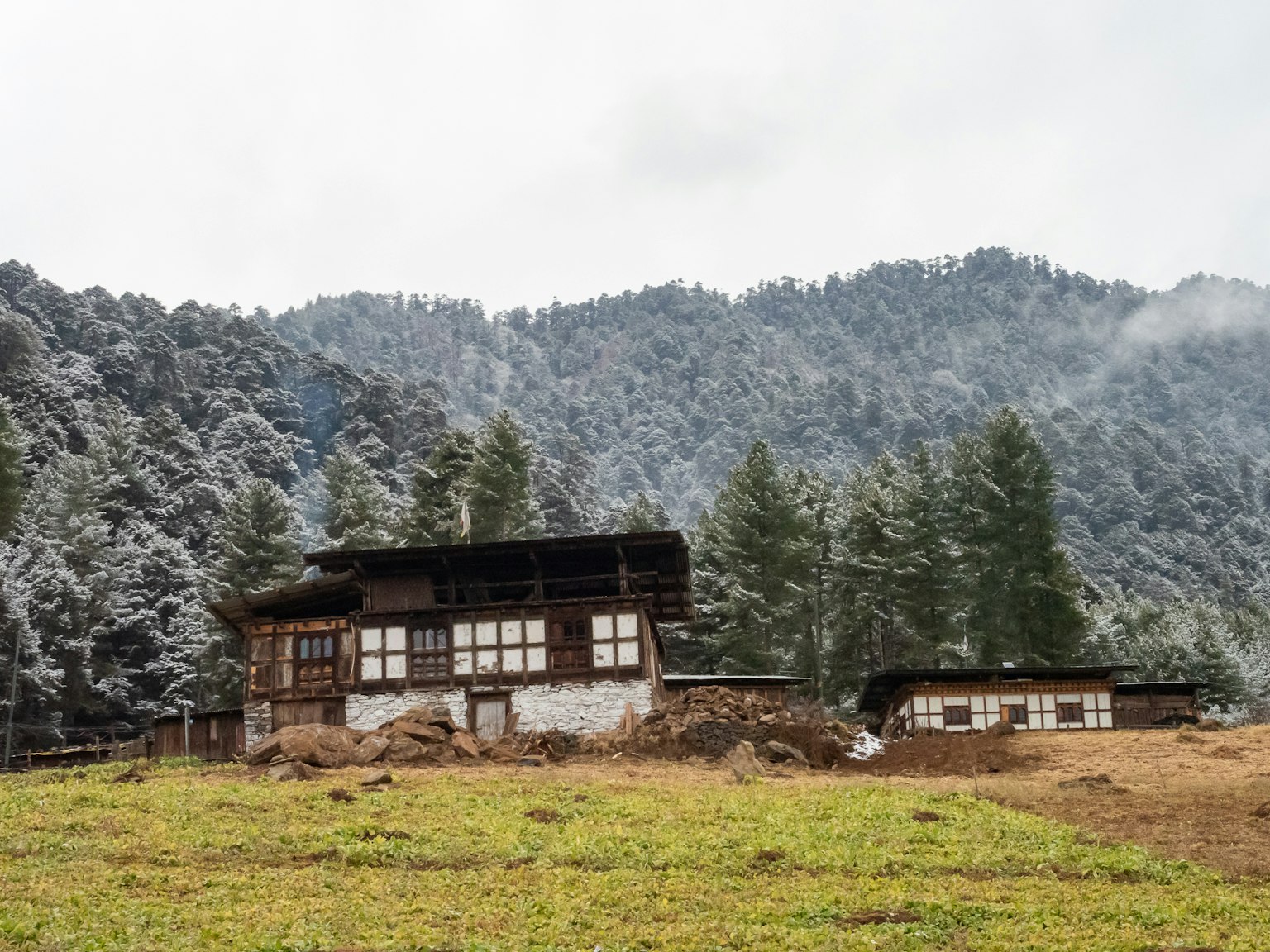 Maisons traditionnelles bhoutanaises avec des montagnes enneigées en arrière-plan