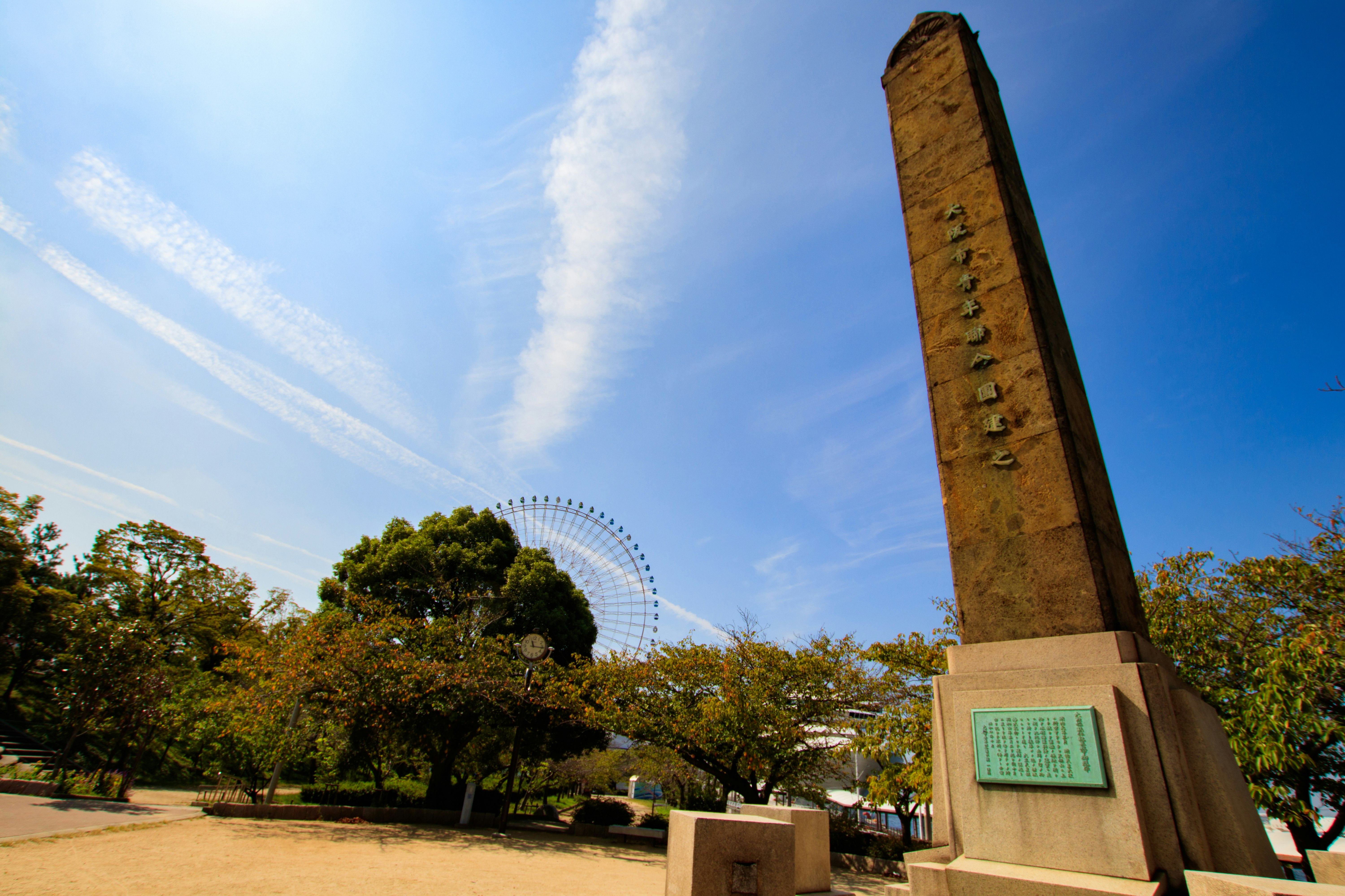 青空の下にそびえる記念碑と広場の風景