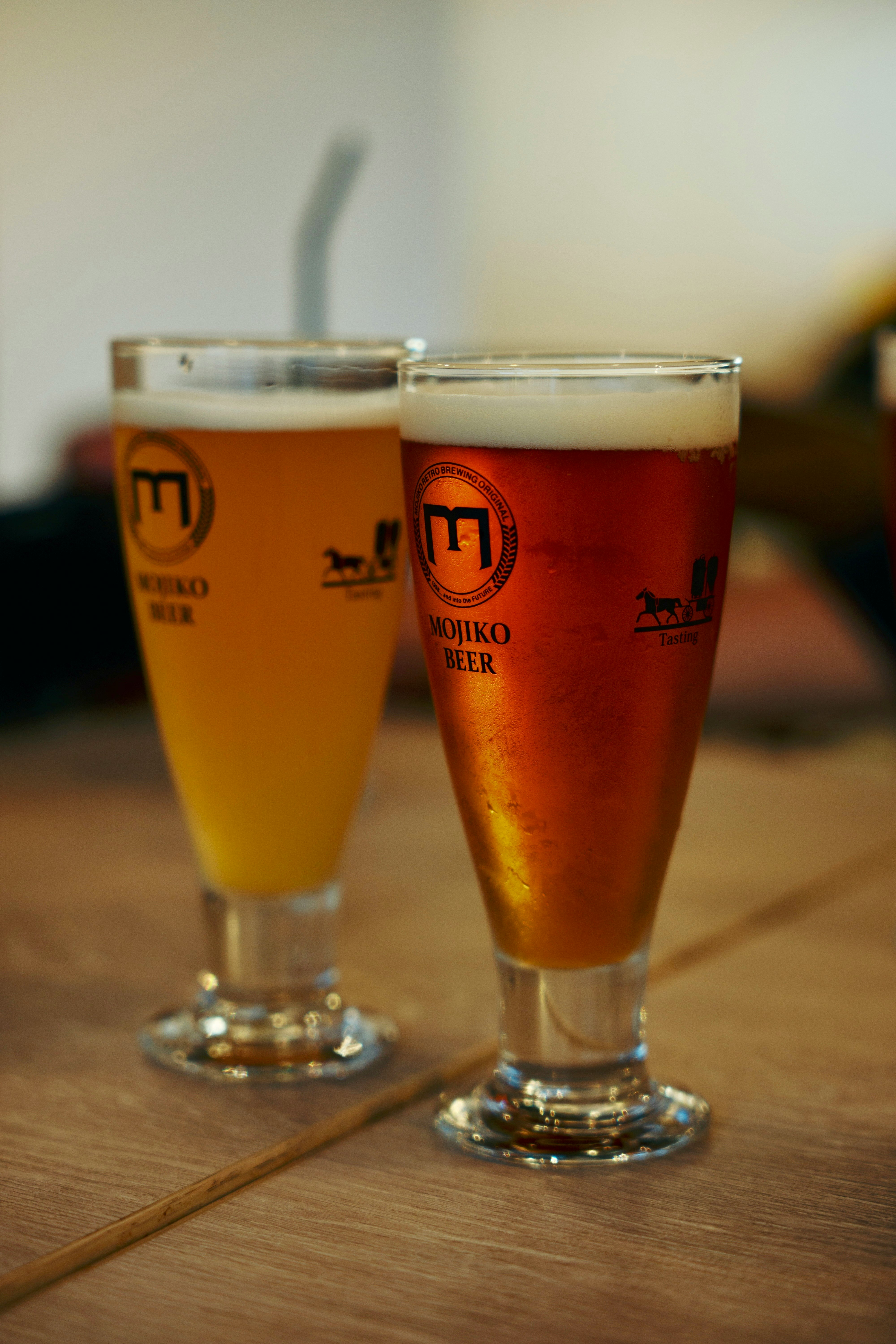 glasses of beer and an orange cocktail on a wooden table