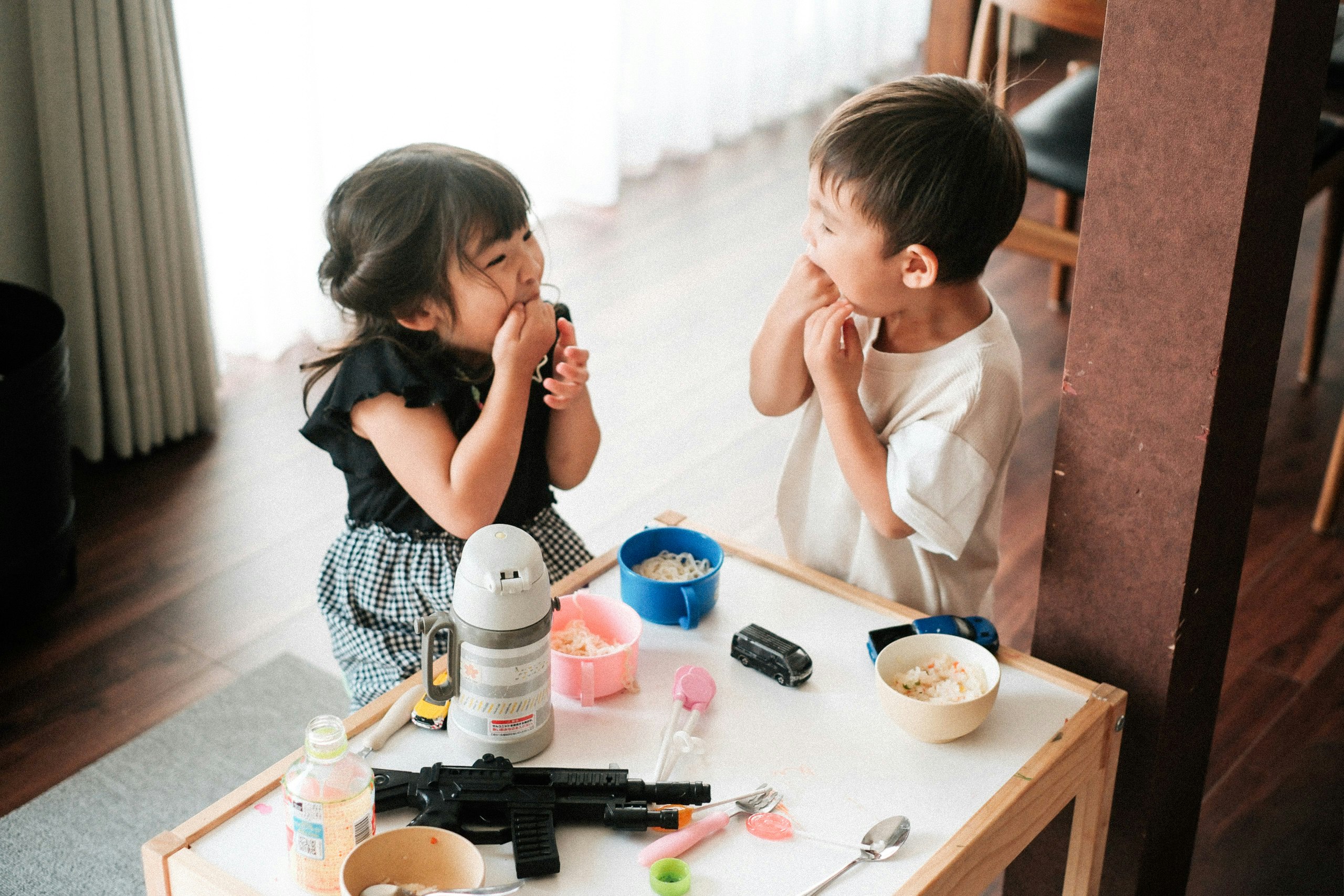 リビングでおもちゃを前に見つめ合う子どもたち