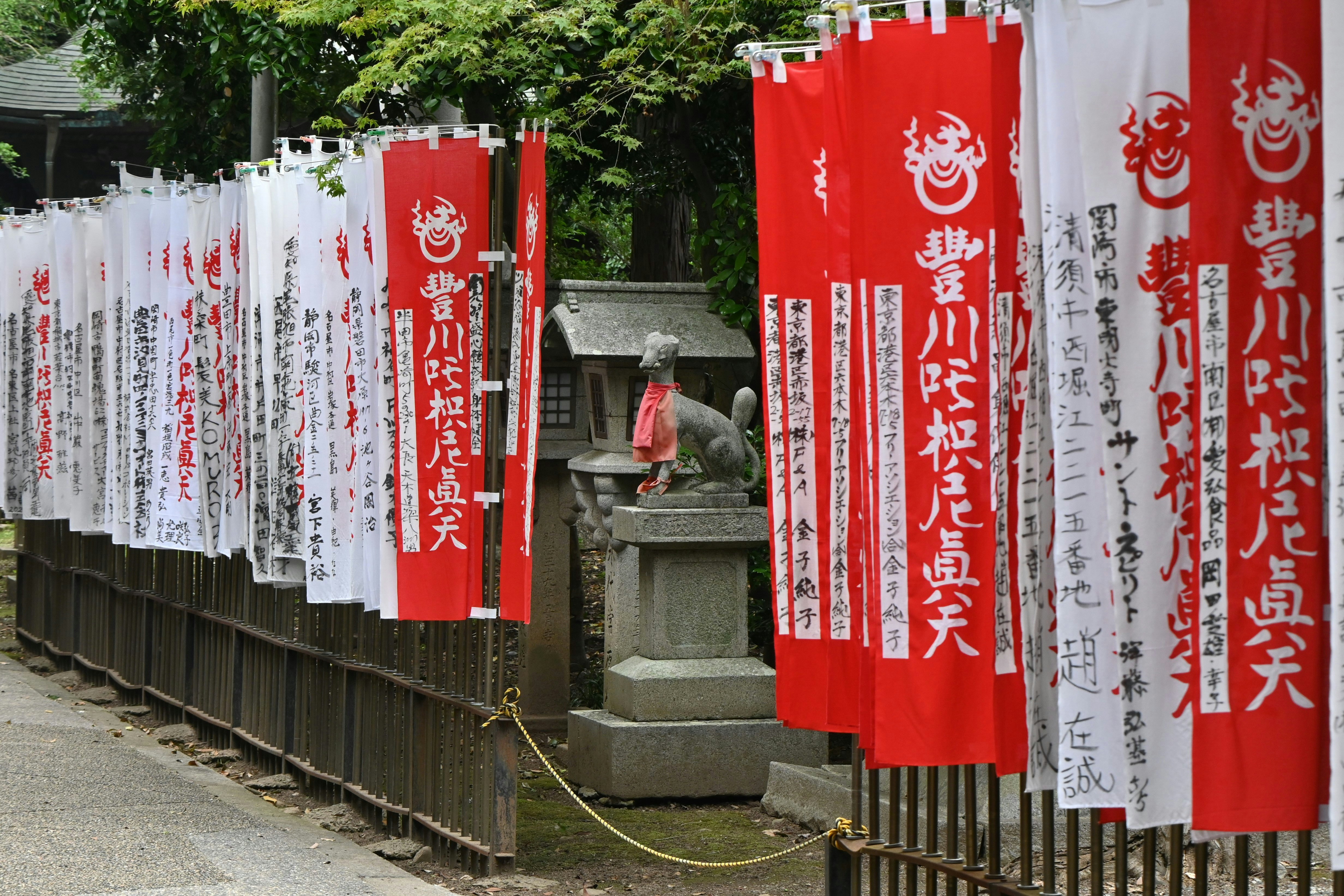 豊川稲荷の千本のぼりと狐像のある参道