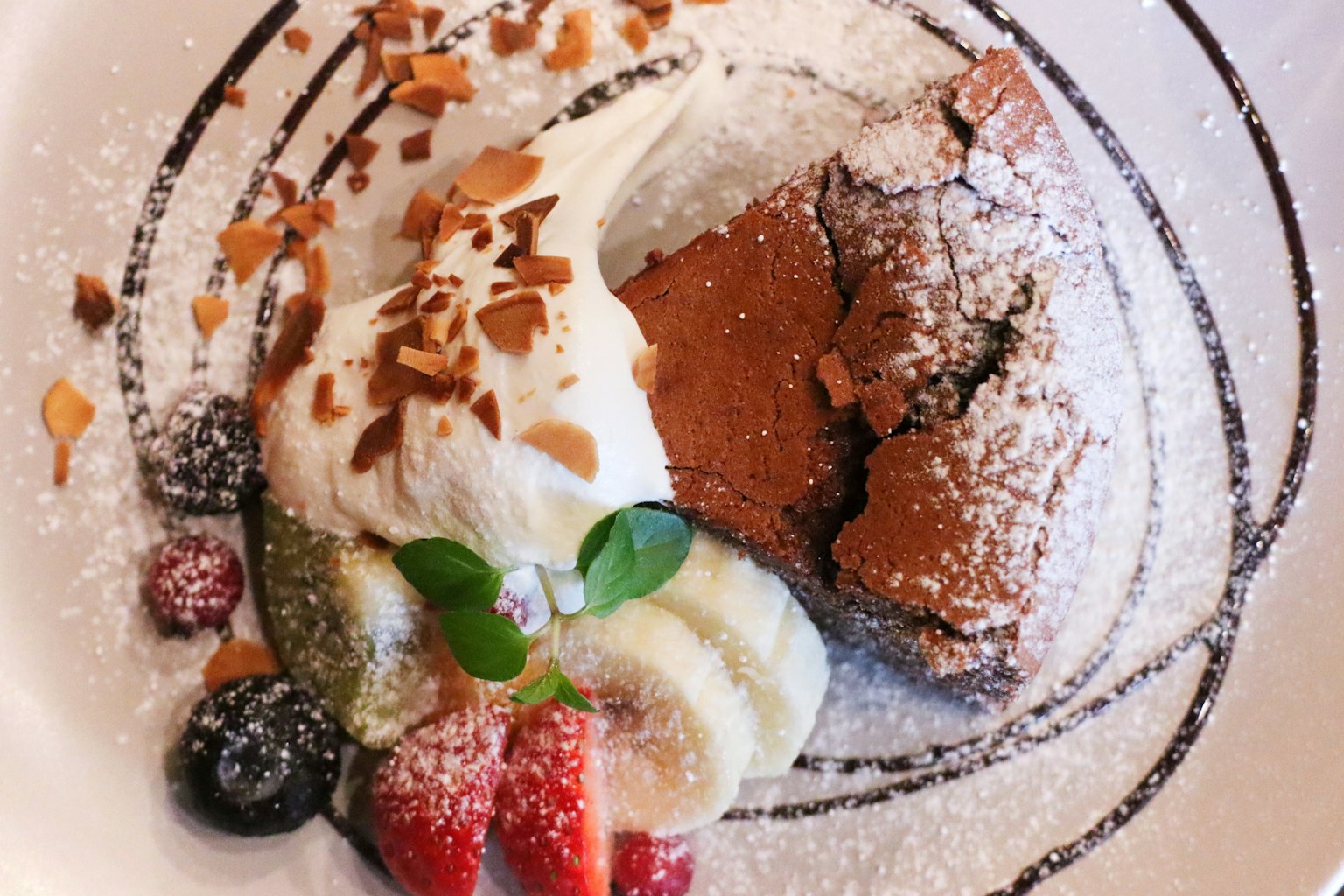 Gâteau au chocolat avec de la crème fouettée et des fruits assortis
