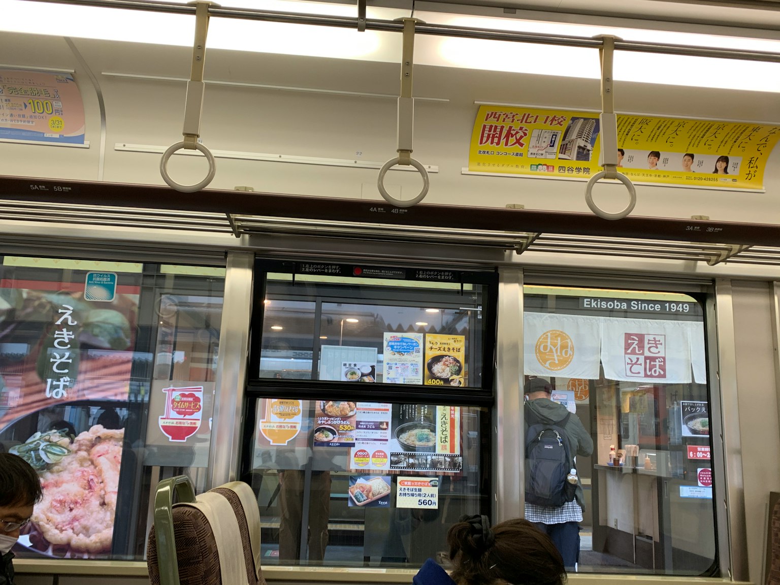 Interno di un treno con vista su insegne di ristoranti fuori dalla finestra