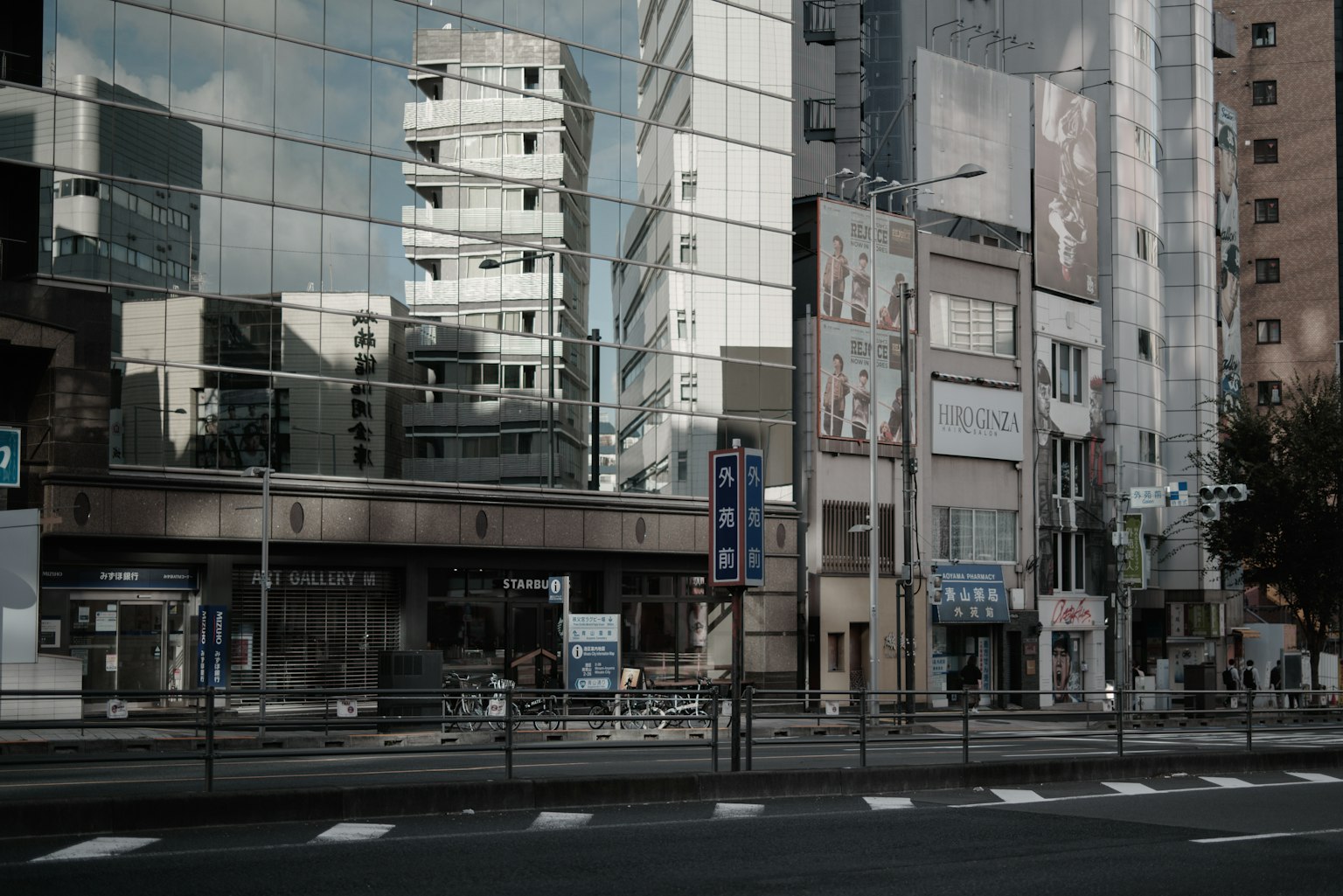 Modern cityscape with glass buildings reflecting light and a quiet street