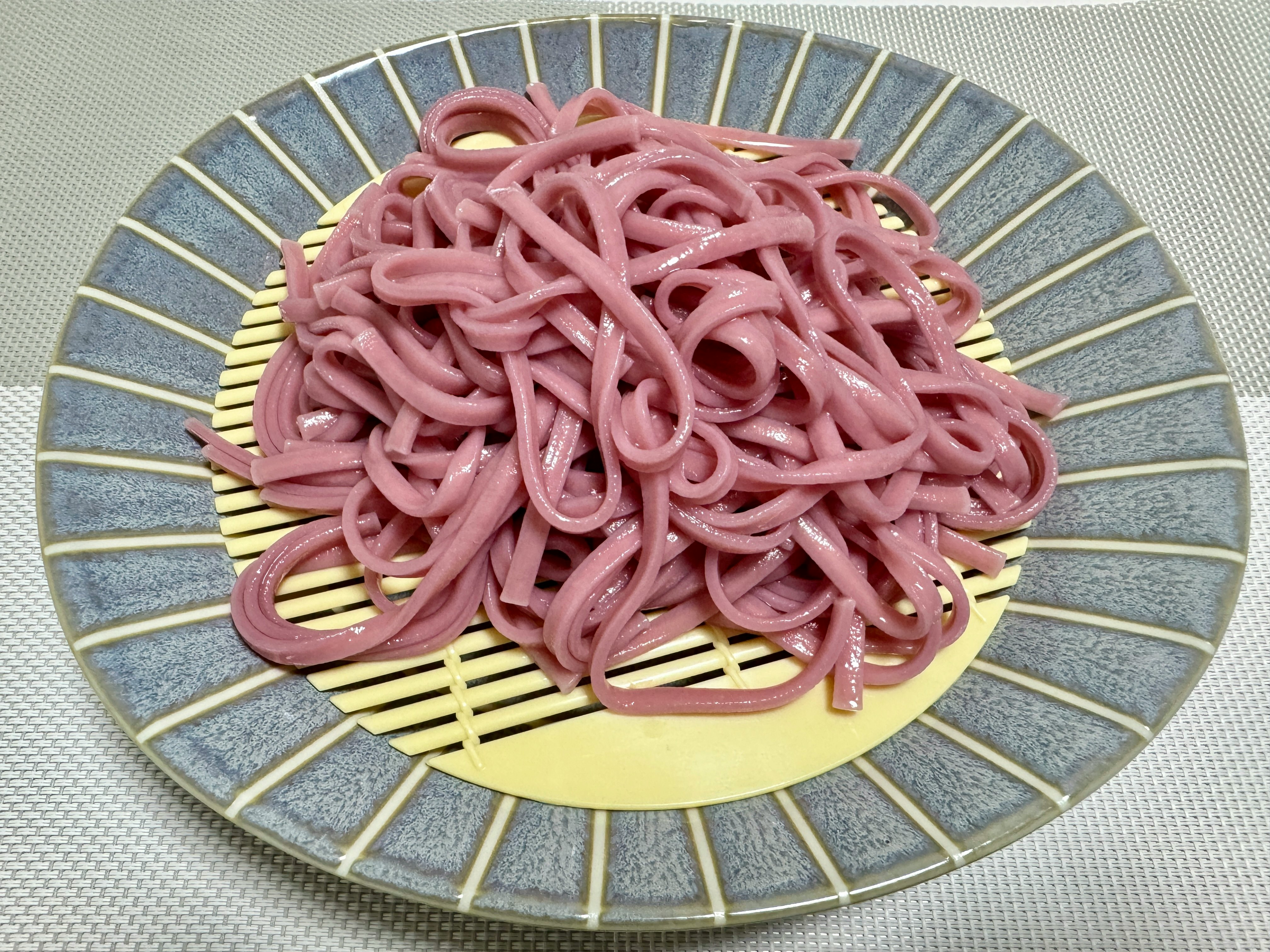ピンクの麺が盛られた皿