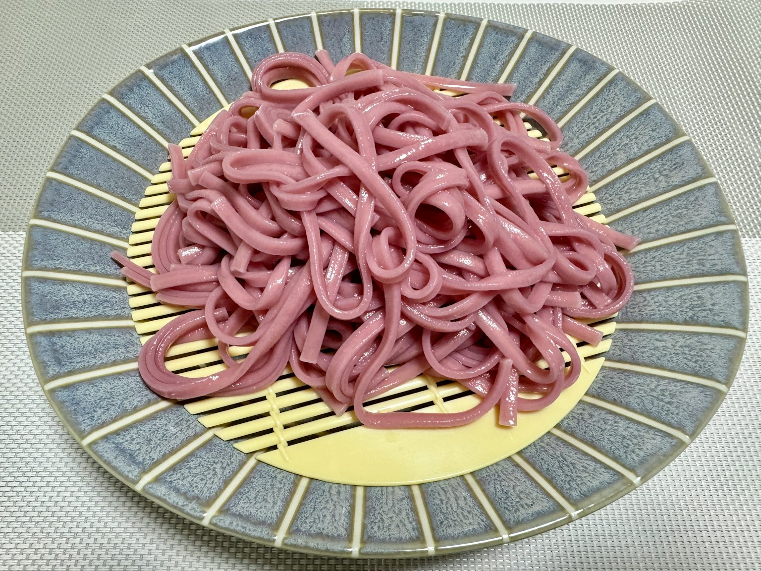 Noodles rosa serviti su un piatto giapponese tradizionale