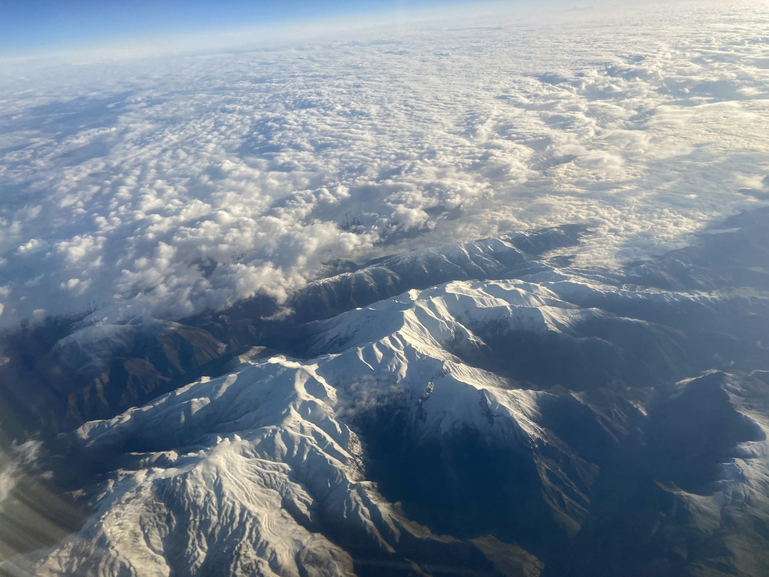 Snow-covered mountains visible above the clouds