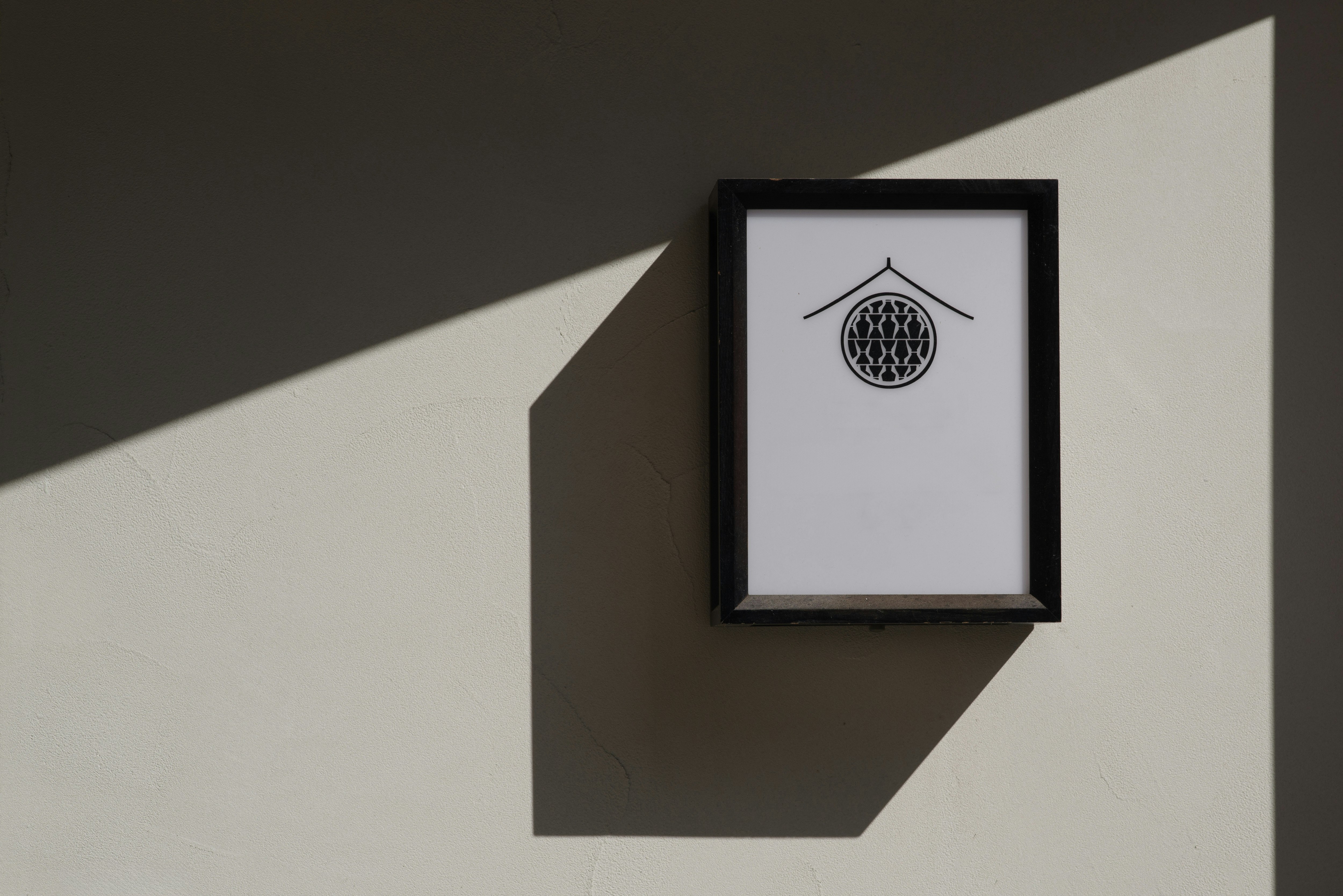 cartel de pared con logo enmarcado sobre pared geométrica imagen