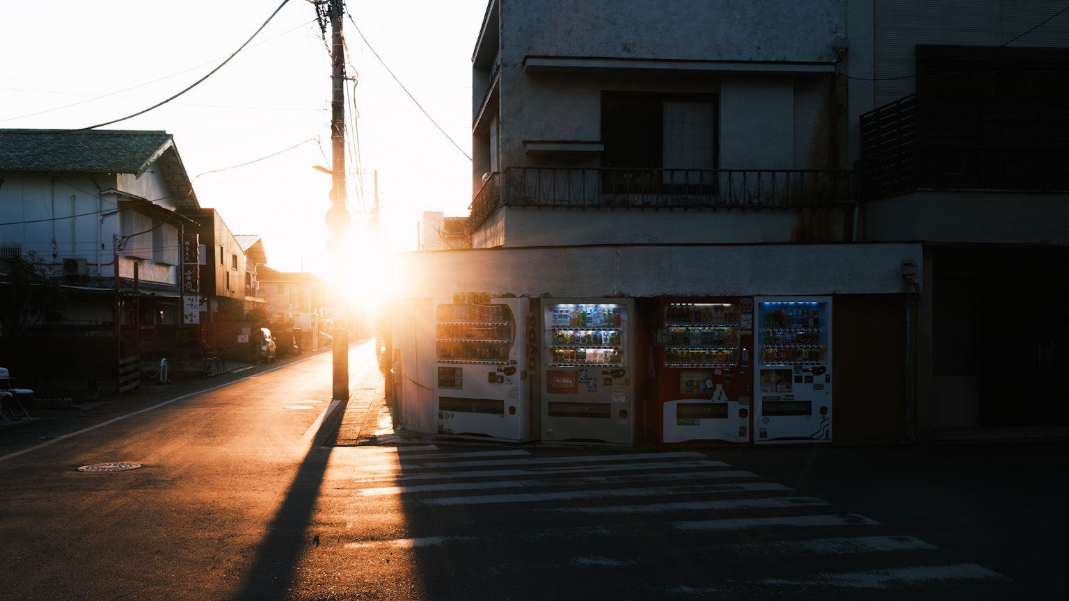 Street view at sunset featuring vending machines and buildings