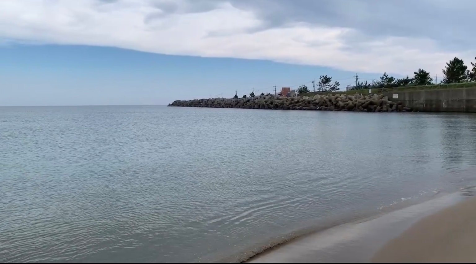 平静的海洋与阴云密布的天空沙滩和防波堤