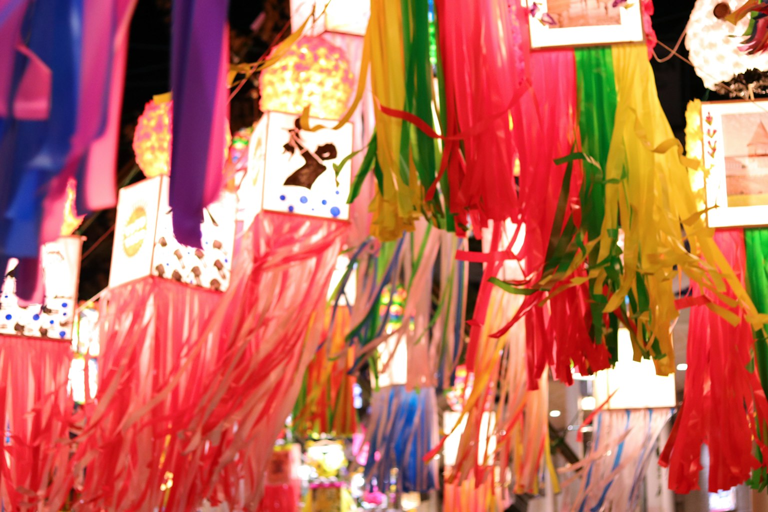 Vibrant ribbons and decorations hanging in a lively market scene