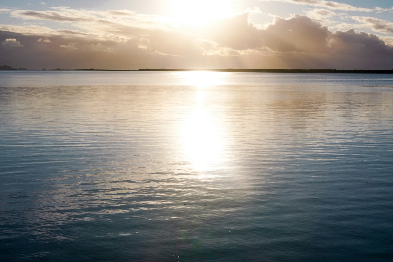 Luce solare che si riflette sull'acqua calma con nuvole morbide