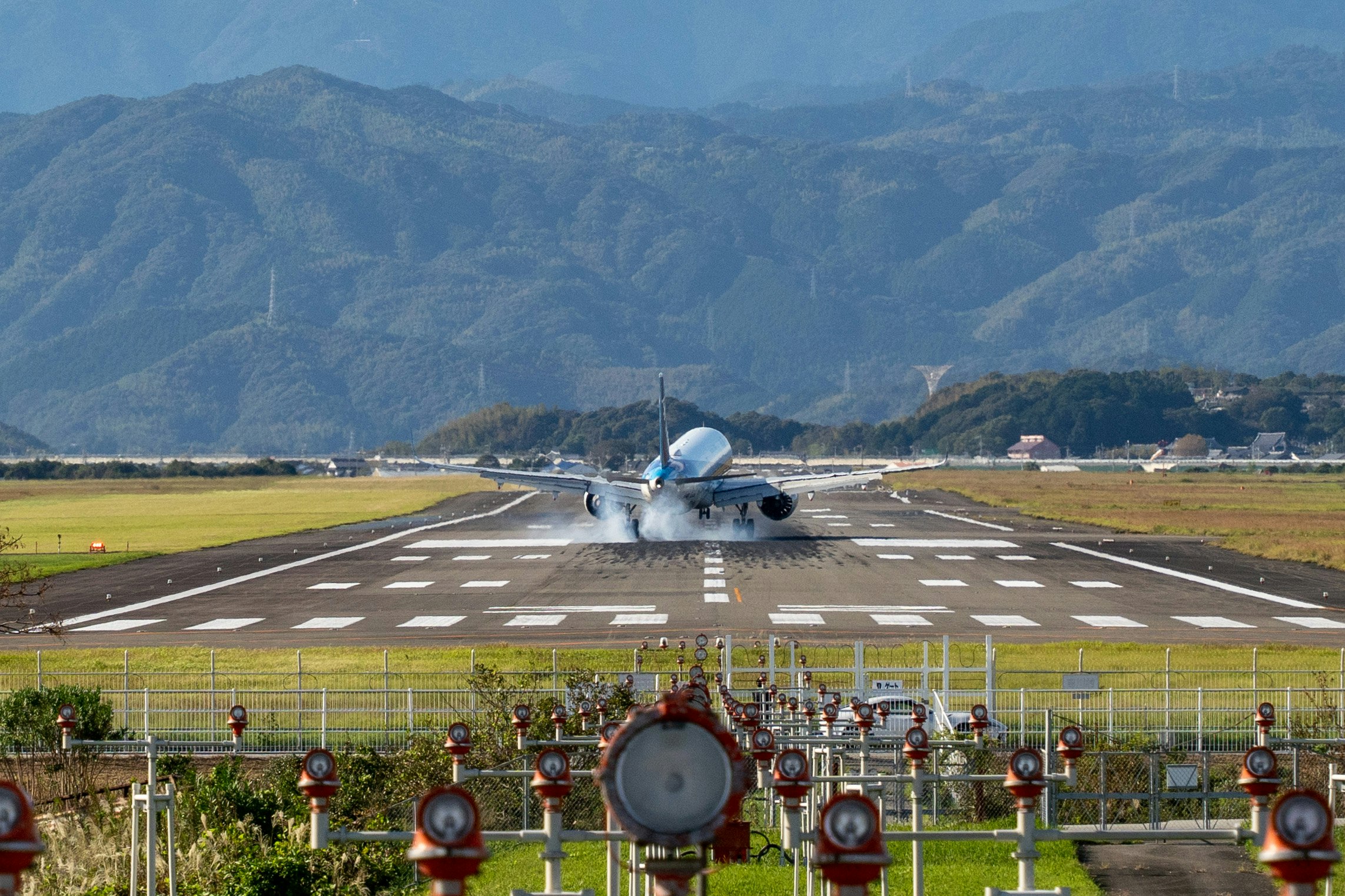滑走路に駐機する旅客機と山並みの背景
