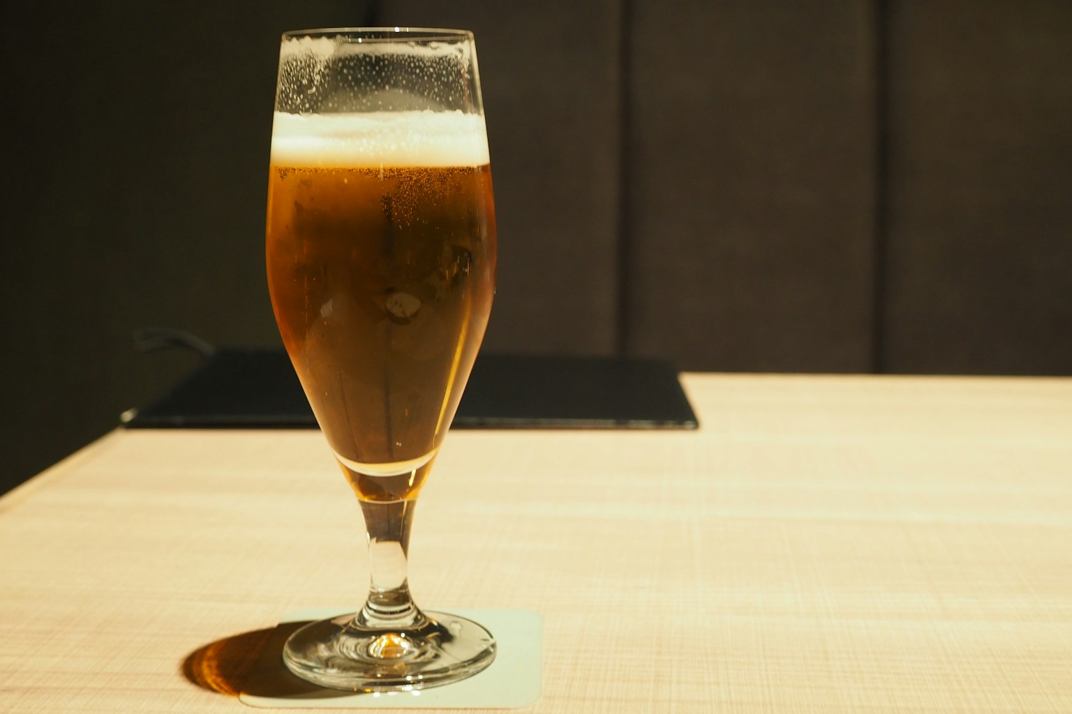 A glass of beer placed on a wooden table