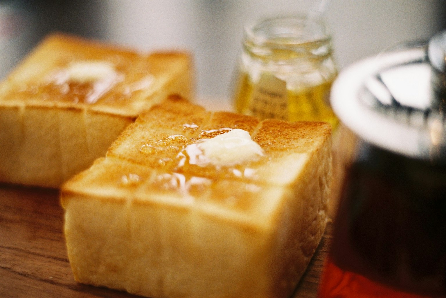 Scheiben von geröstetem Brot mit Butter und Honig oben drauf