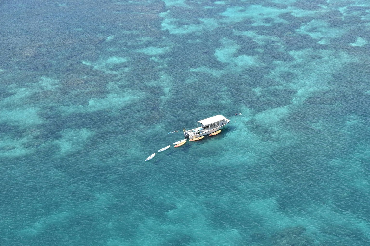 Barca che galleggia su un oceano blu con barriere coralline