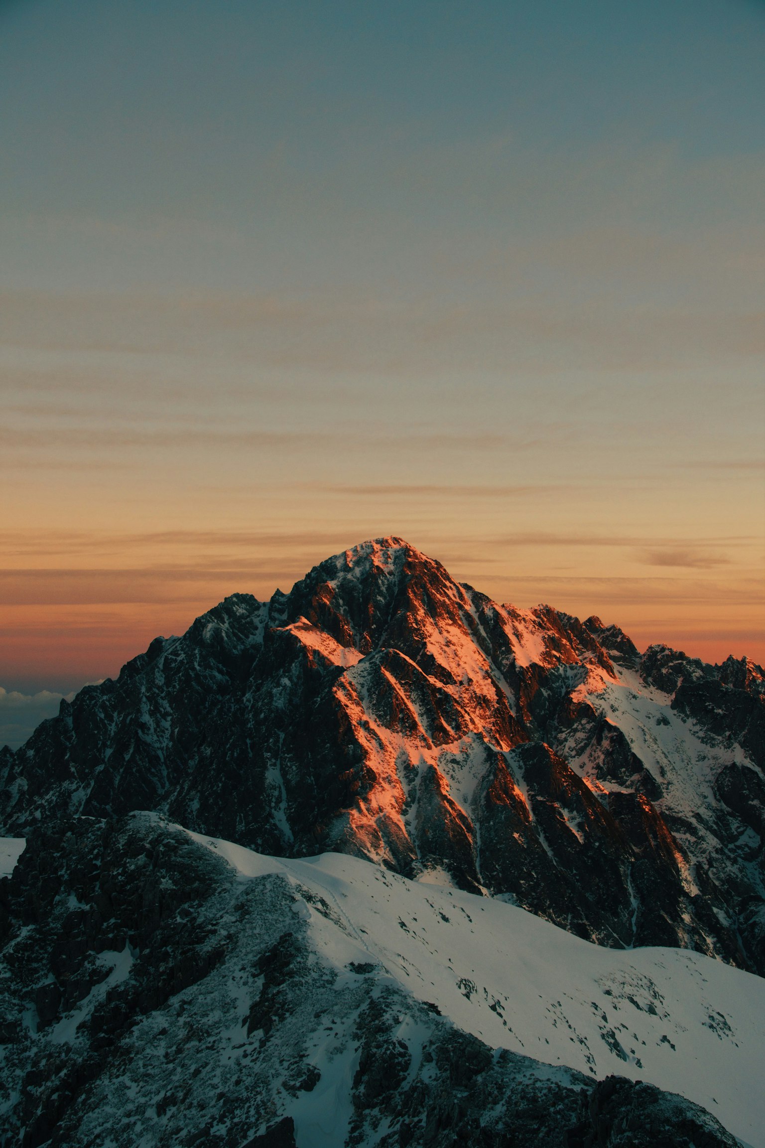 Schneebedeckter Berg mit einem atemberaubenden Sonnenuntergangshimmel