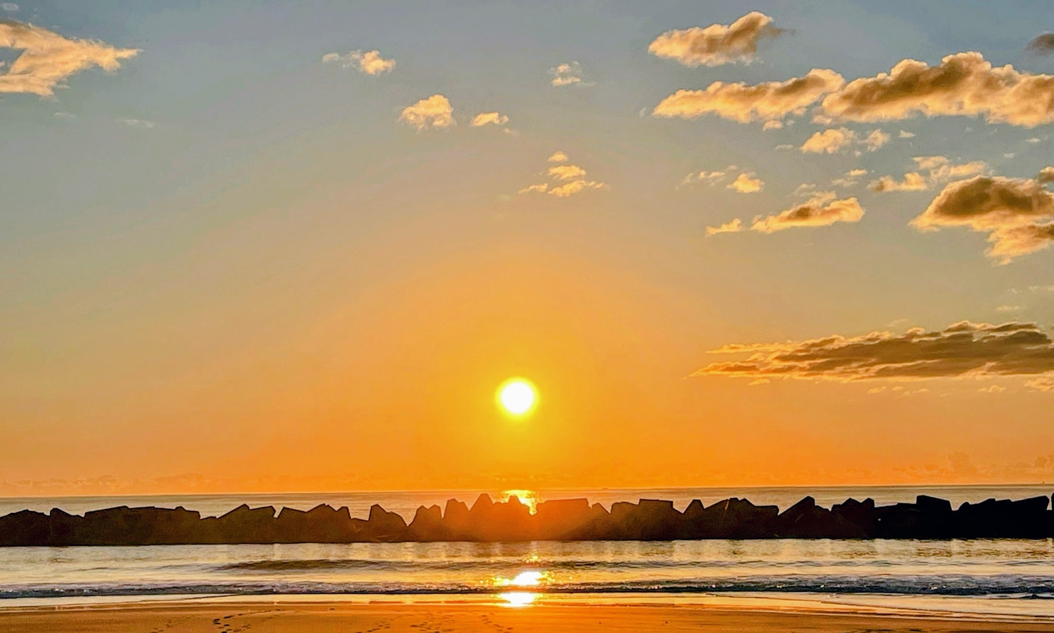 Bellissimo paesaggio del sole che tramonta sull'oceano con cielo sfumato arancione e blu