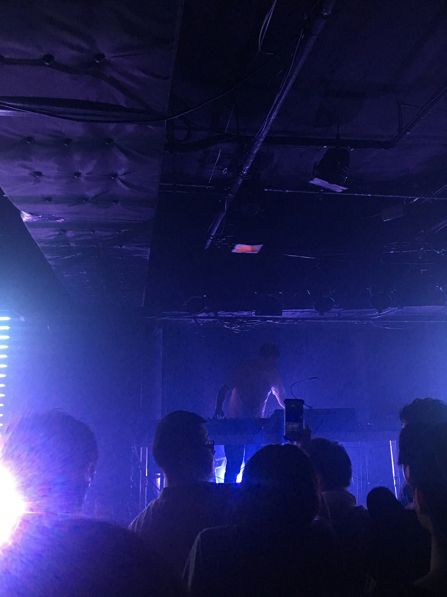 Silhouettes d'un artiste se produisant dans un club sombre avec un public