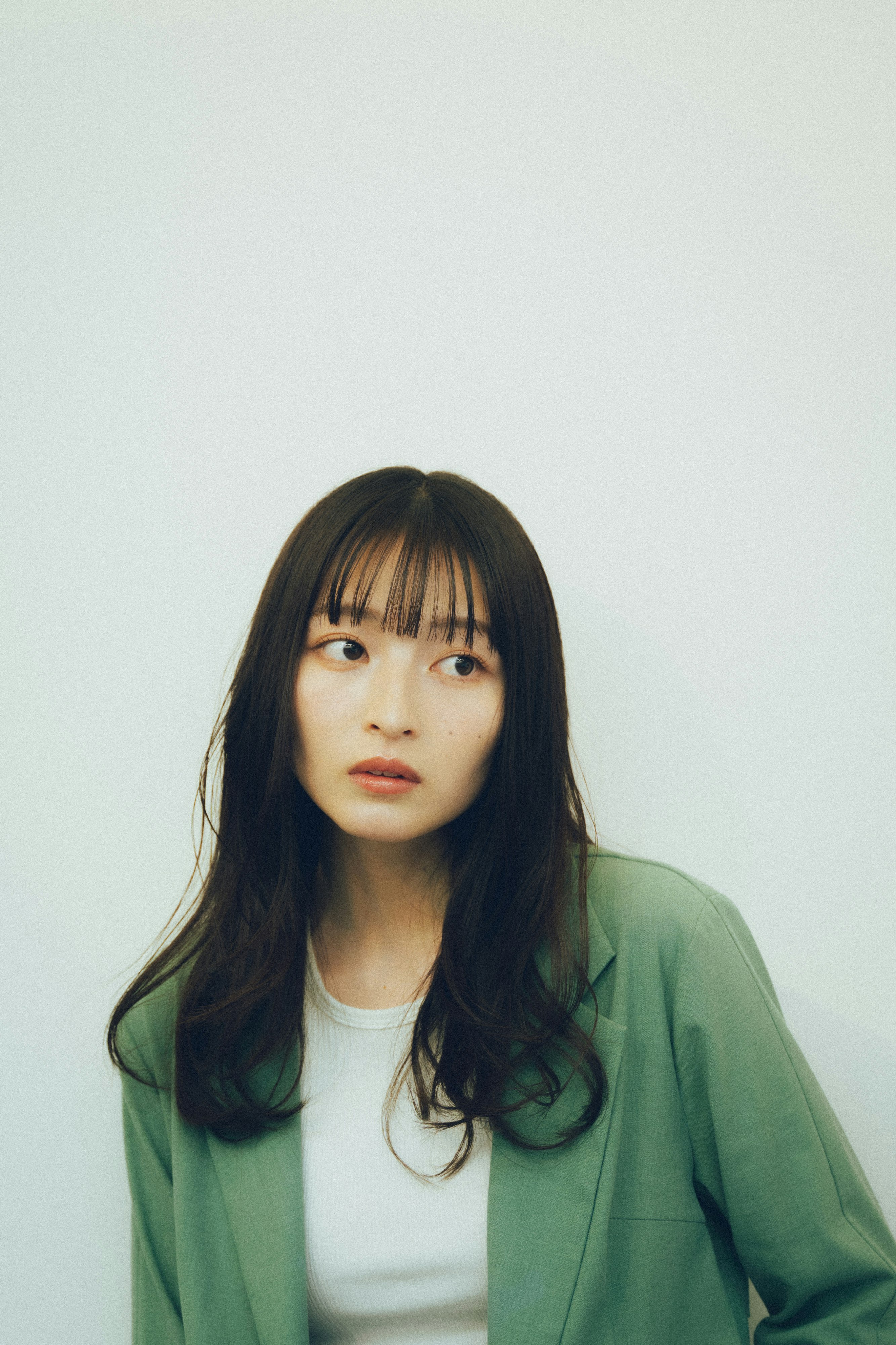 白背景の緑のジャケットを着た女性