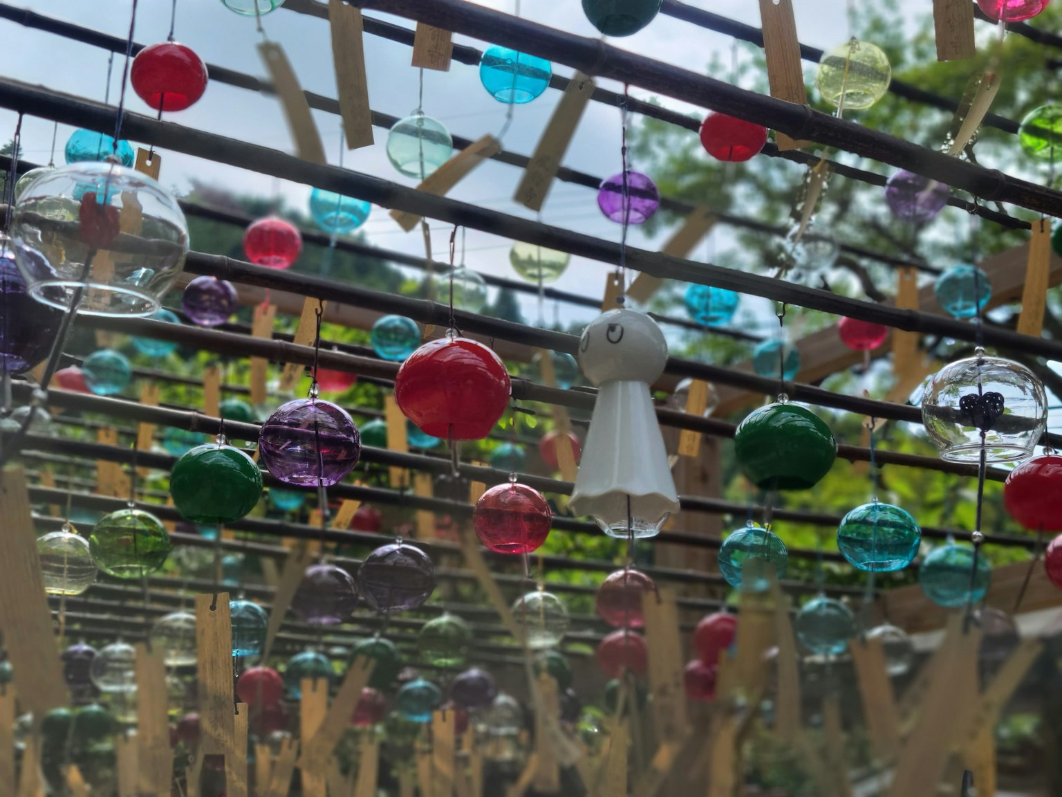 Scène extérieure avec des ornements en verre colorés suspendus à une structure
