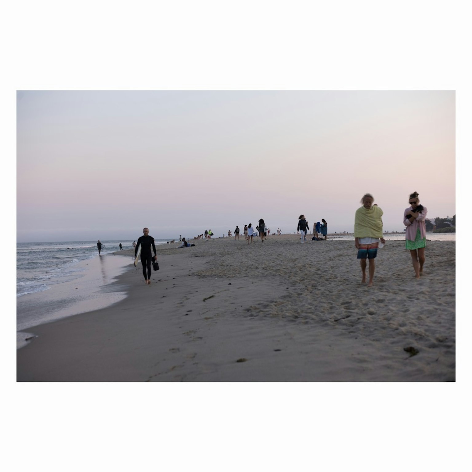 People walking on a beach with a calm sea view