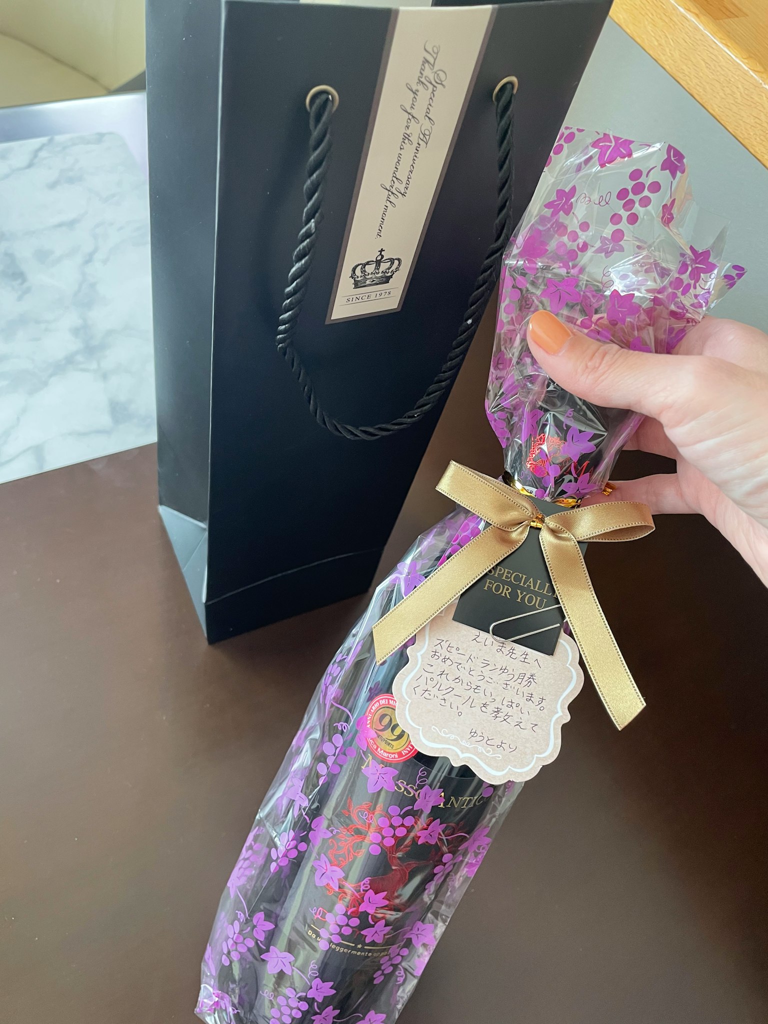 用紫色花朵包装的瓶子和黑色礼品袋
