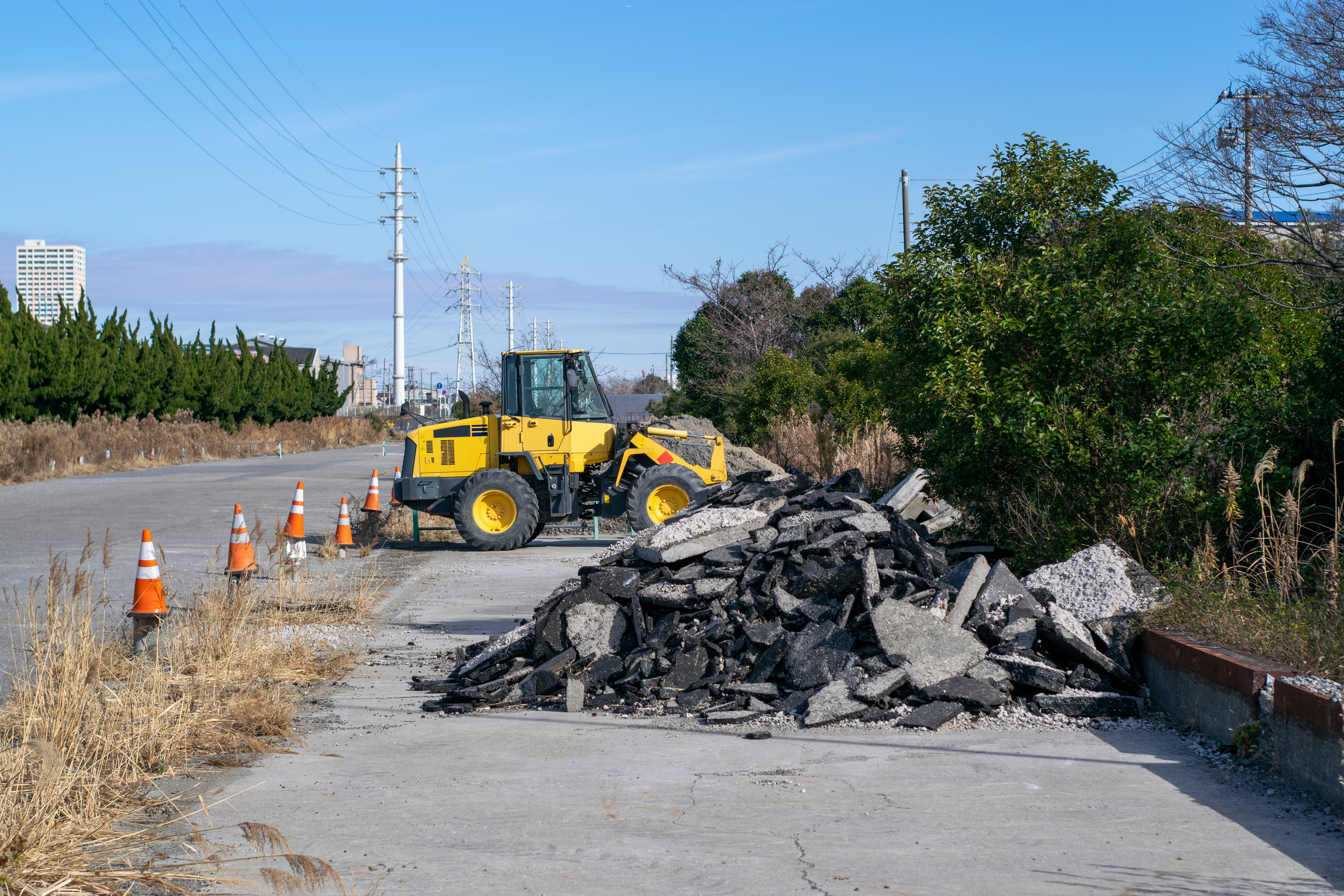 道路脇に積まれた瓦礫と建設用ホイールローダ