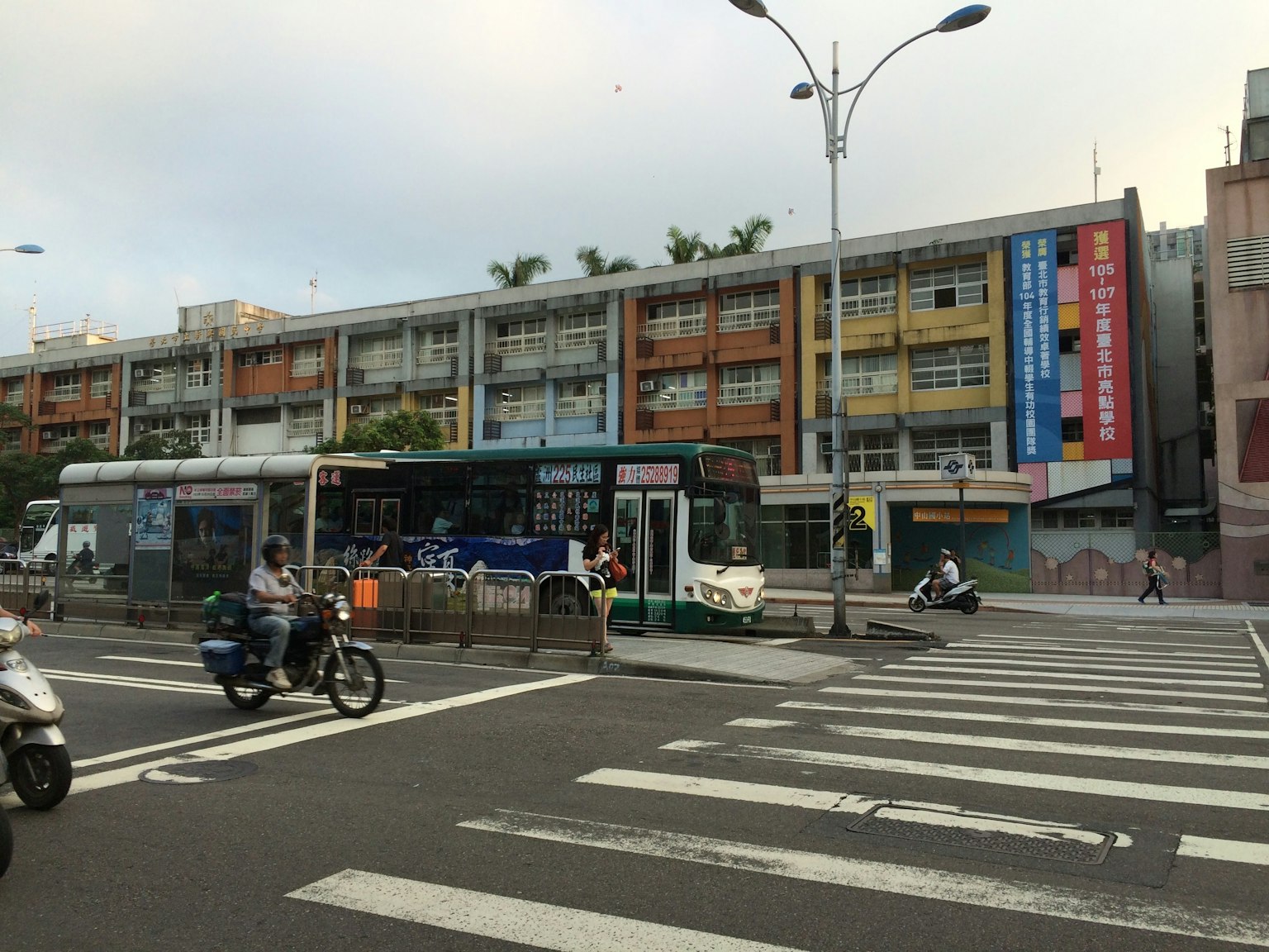 Edificios coloridos a lo largo de una calle con una parada de autobús y un paso peatonal