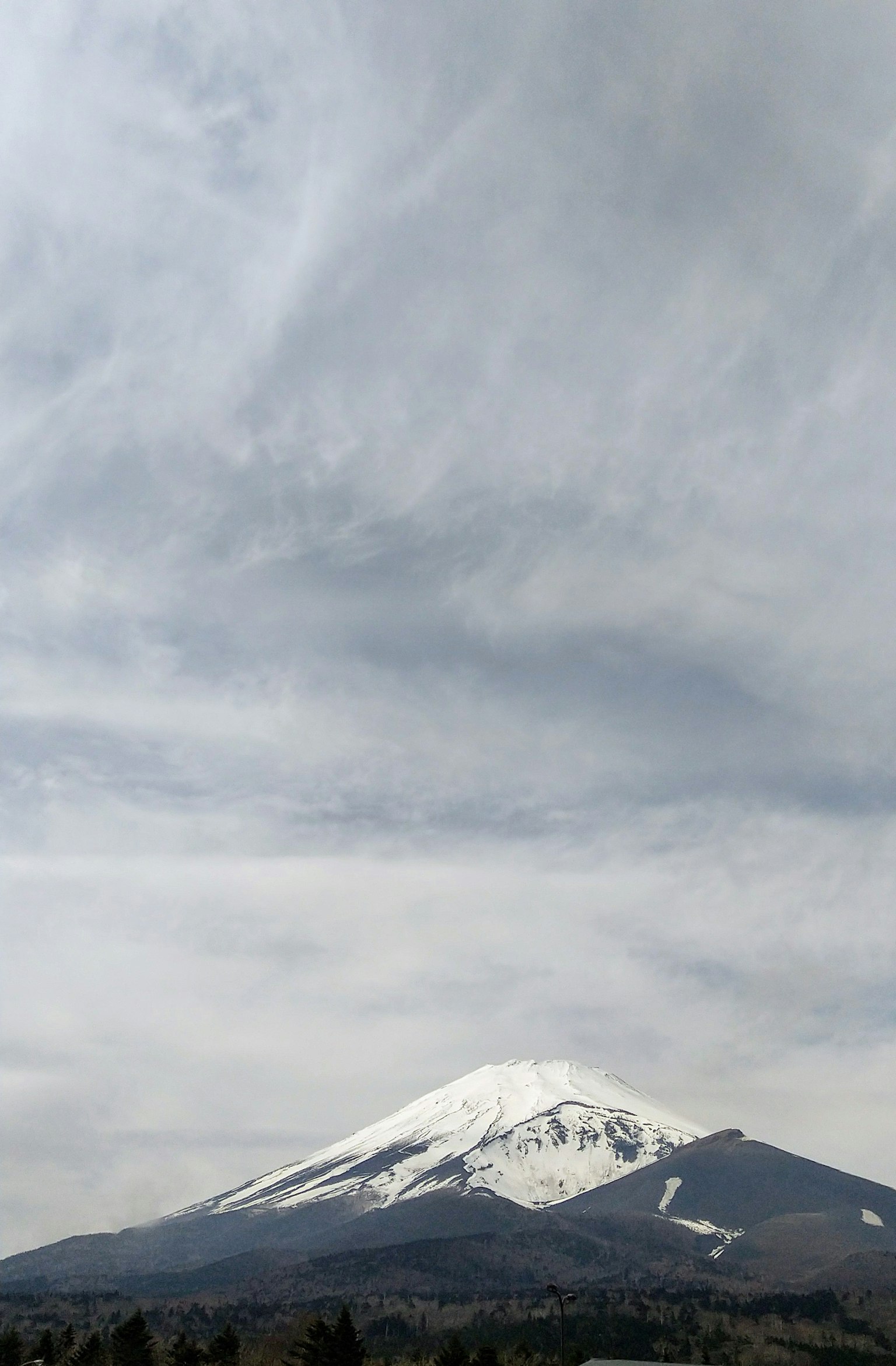 雪覆蓋的富士山在多雲的天空下